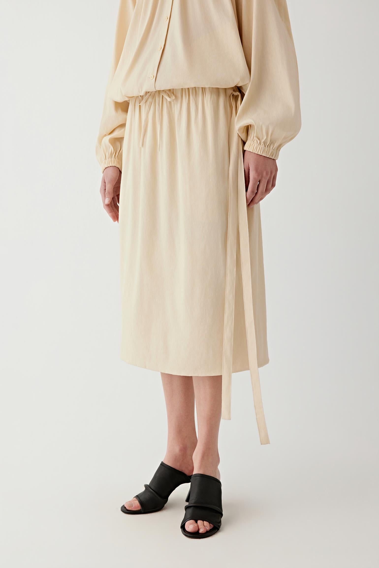 Full-length front view with slight movement, emphasizing the airy volume of the skirt, the way the fabric opens gently from the waistband and the natural flow created by the lightweight woven construction