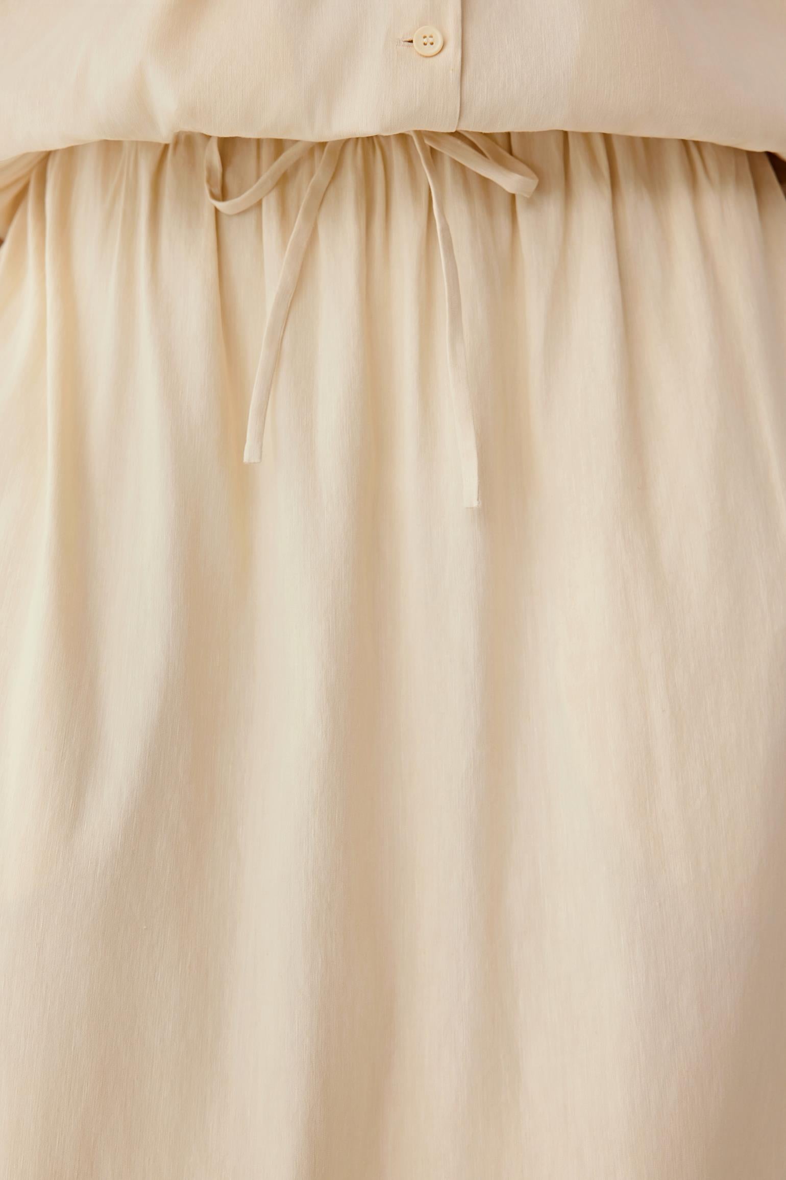 Close-up of the waistband area, showing the elasticated construction, adjustable tie detail and gathered fabric, highlighting stitching and the natural texture of the material