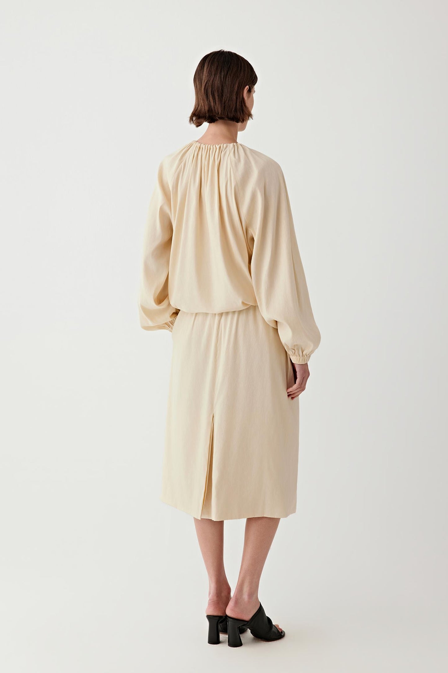 Full-length back view showing the rear silhouette, highlighting the elasticated waistband, the clean fall from waist to hem and the balanced shape of the skirt