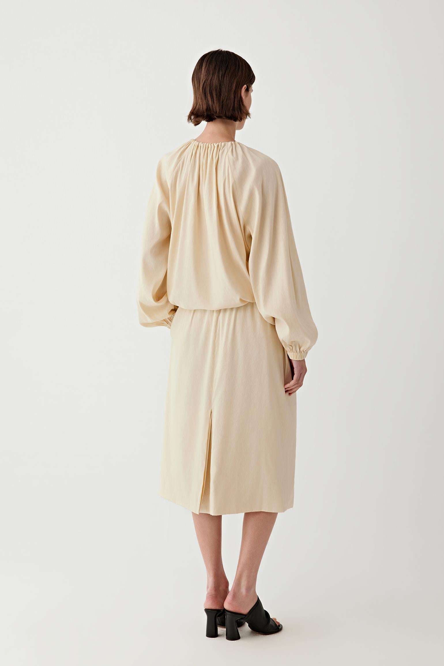 Full-length back view showing the rear silhouette, highlighting the elasticated waistband, the clean fall from waist to hem and the balanced shape of the skirt