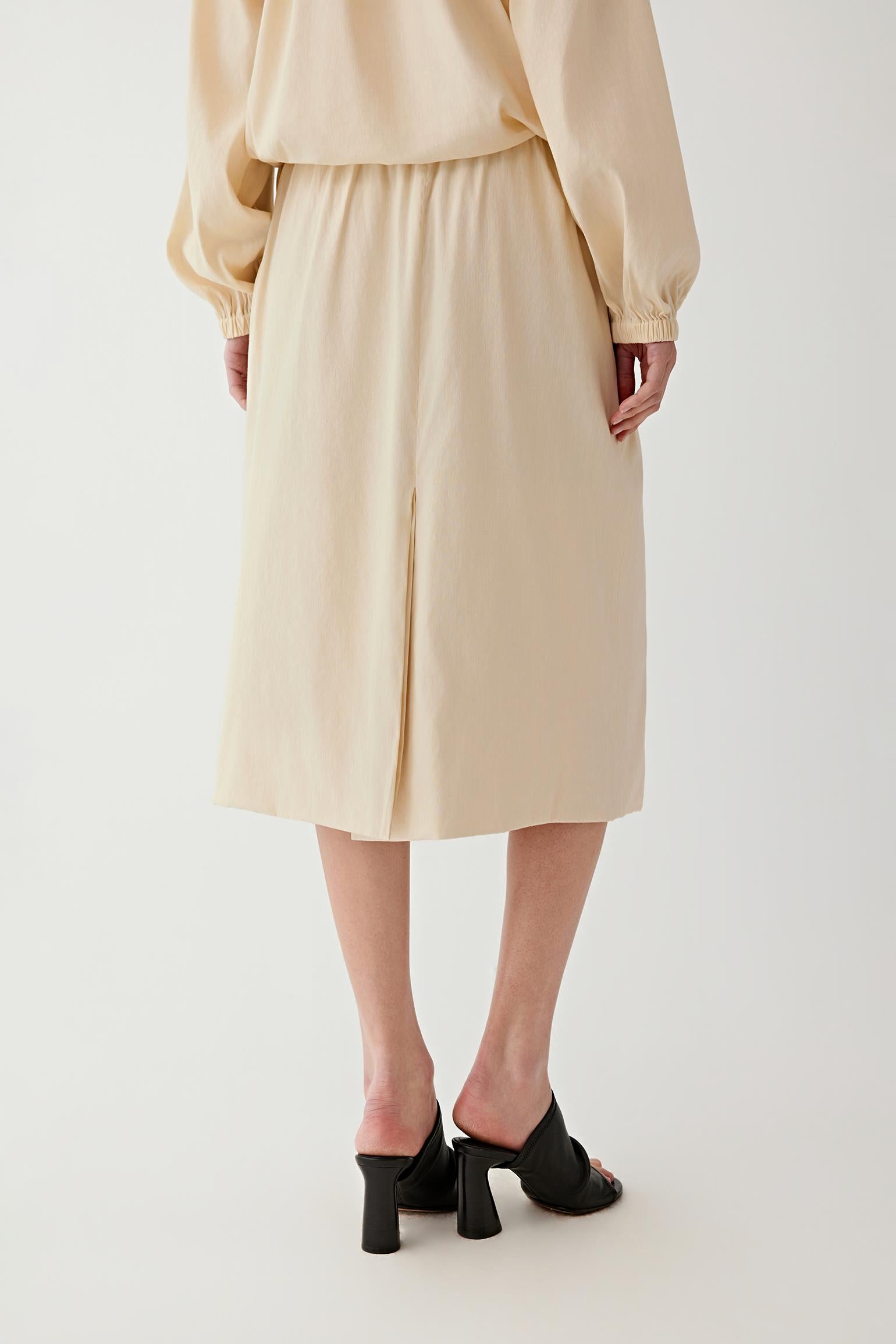 Mid-length view focusing on the skirt from waist to hem, emphasizing the subtle volume, the even distribution of gathers and the softly textured surface of the linen blend