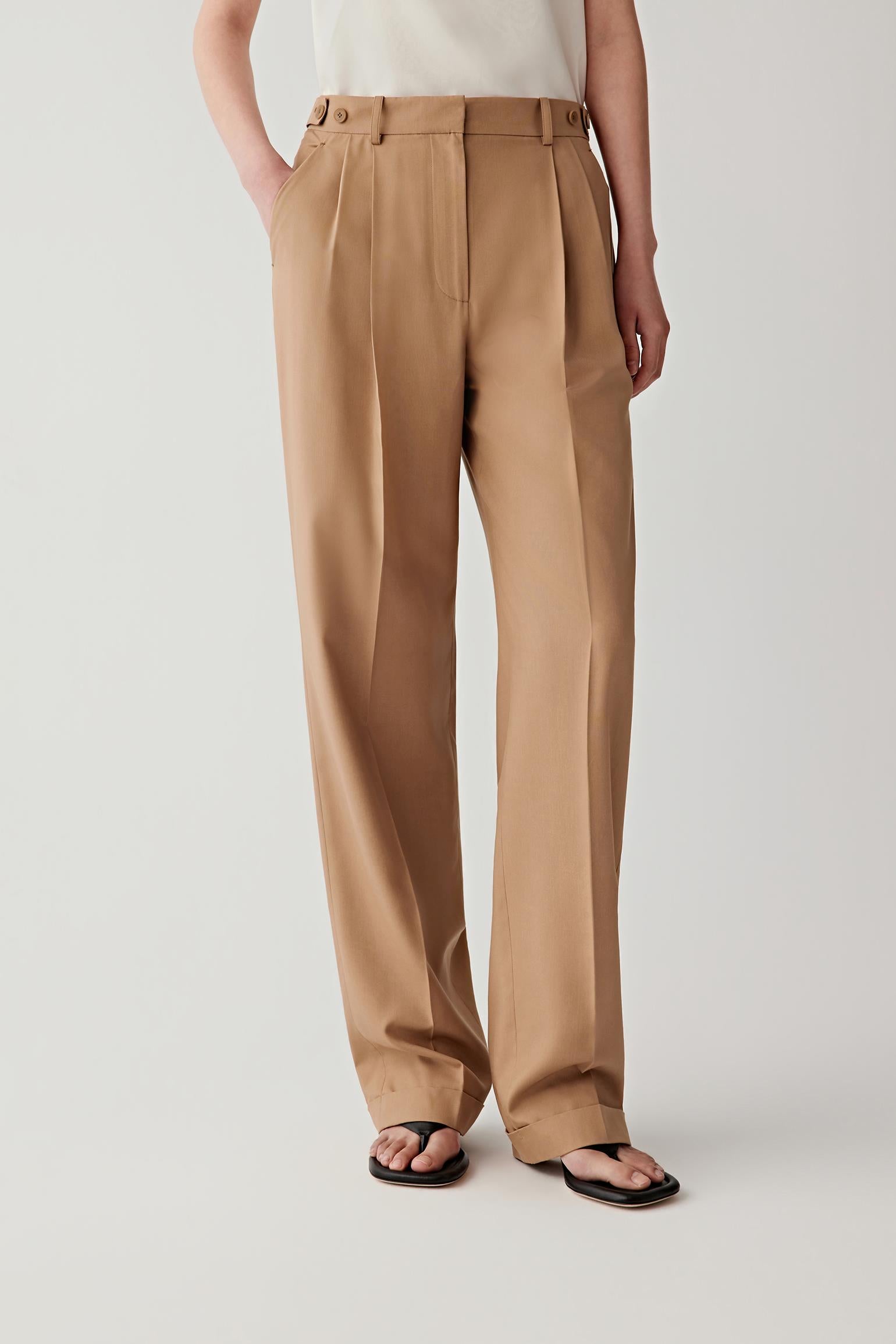 Front or three-quarter view emphasizing the straight-leg silhouette, tailored waistband and front pleats, showing the elongated line of the trousers