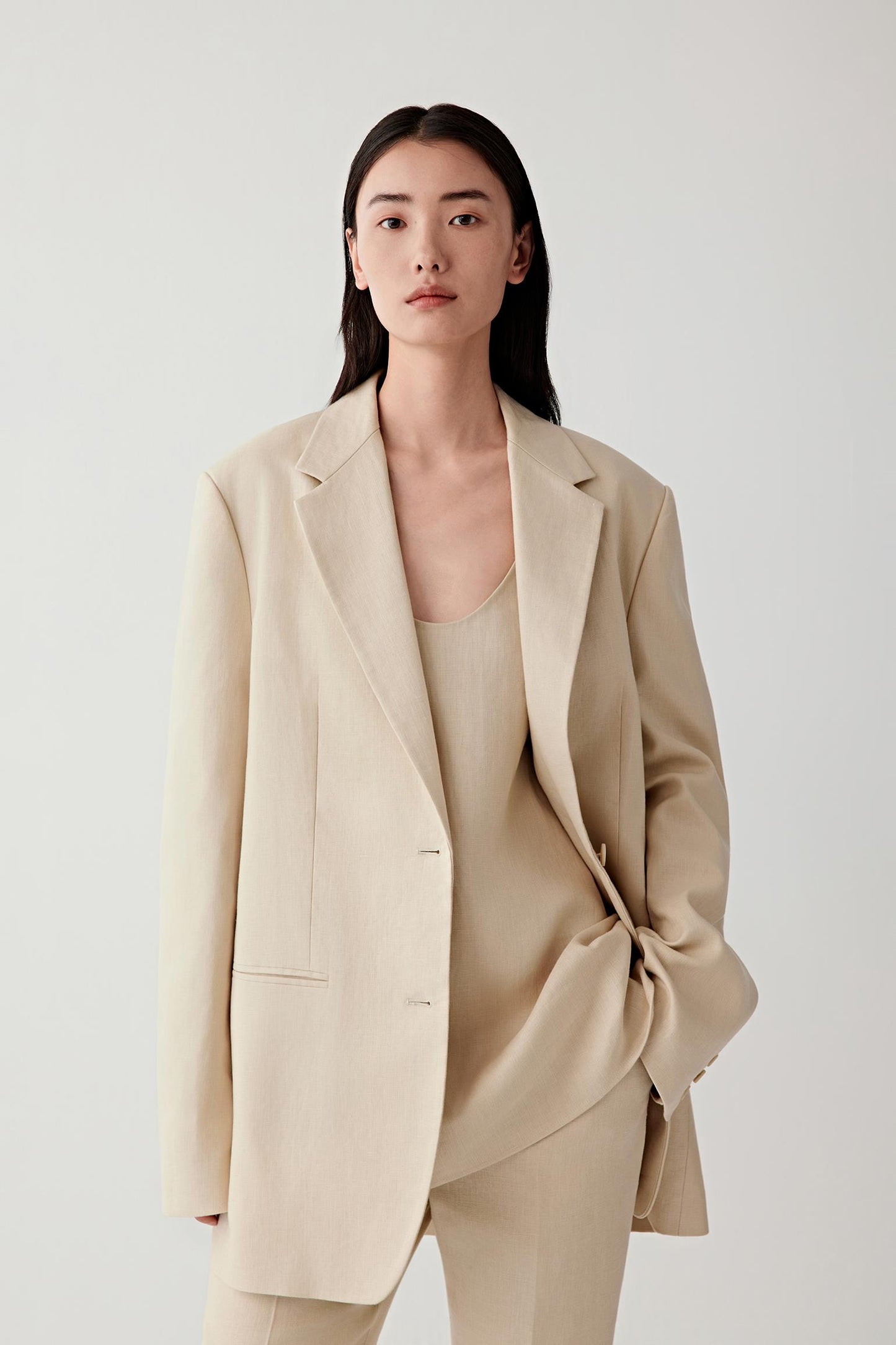 Three-quarter view showing the clean lapels and straight cut.