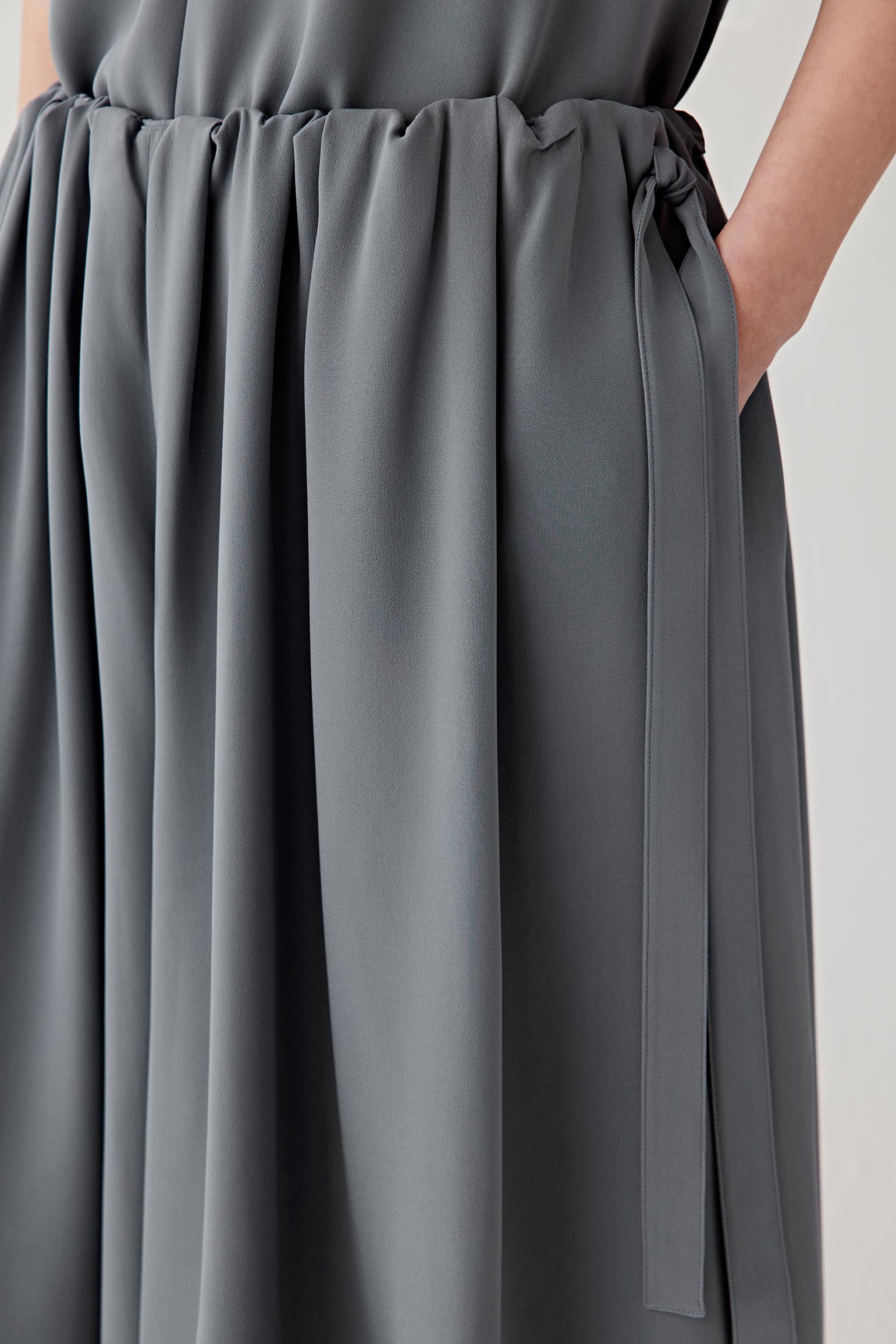 Close-up of the waistband detailing the elasticated gathered construction and soft pleat formation. The image highlights the matte finish and lightly textured surface of the silk crepe.