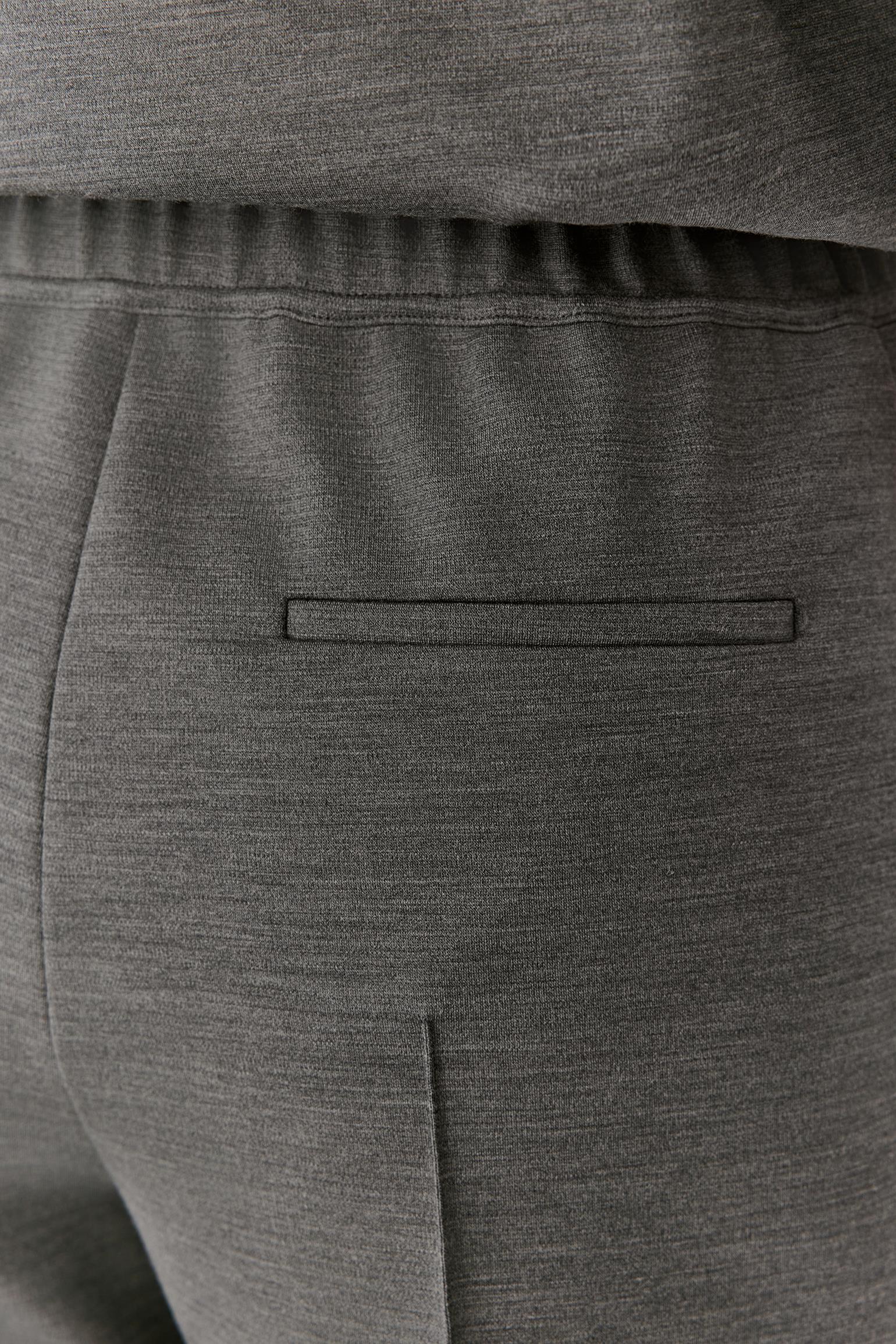 Close-up of dark gray heathered fabric clothing showing an elastic waistband, a horizontal welt pocket, and a vertical seam.