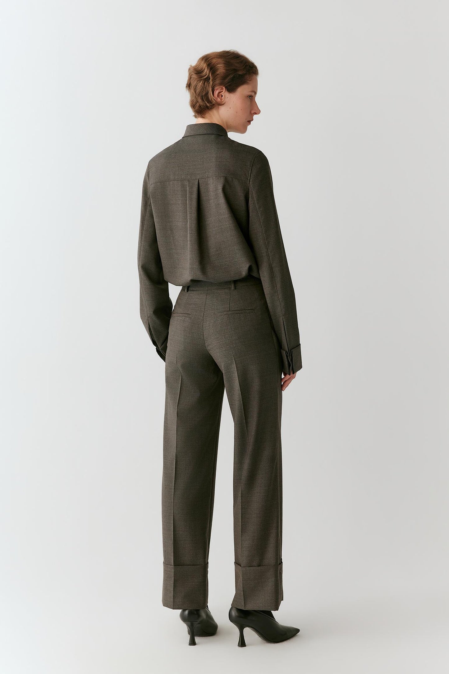 Three-quarter view highlighting the long sleeves, side slits and relaxed silhouette.