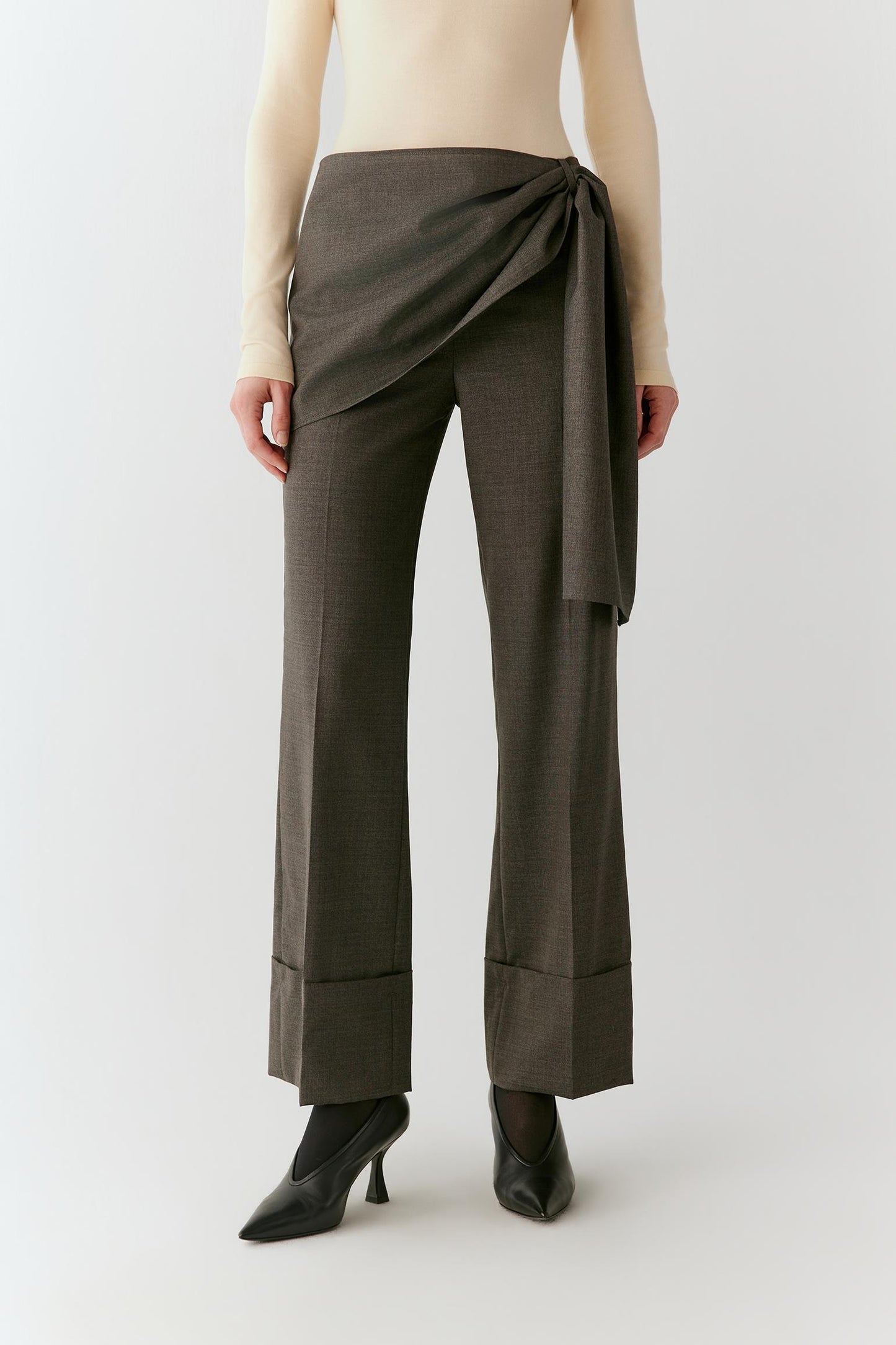 Full-length front view emphasizing the straight-leg cut, asymmetric waist detail and turned-up cuffs.