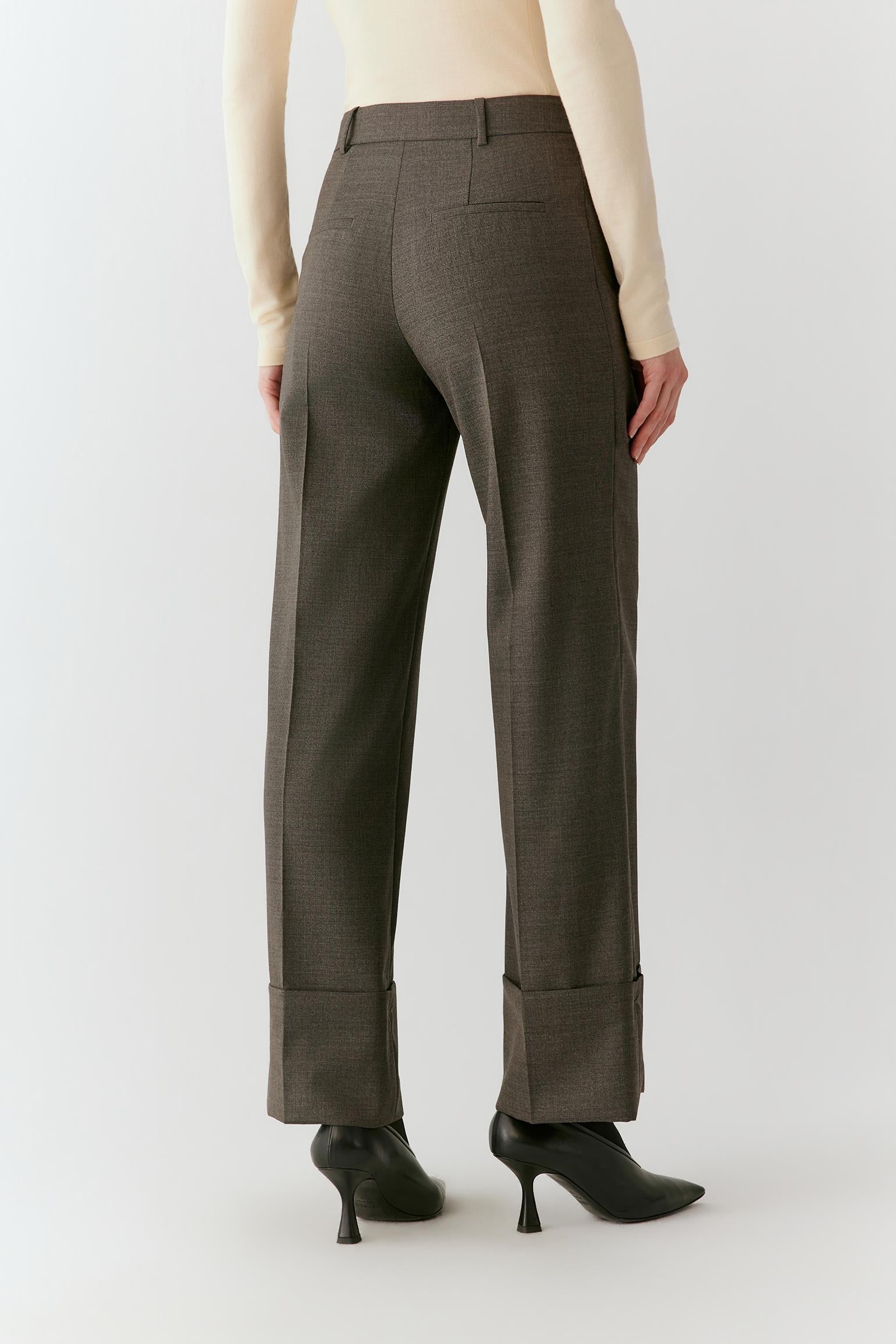 Three-quarter front view highlighting the wrap-front construction, clean tailoring and subtle melange texture of the wool.