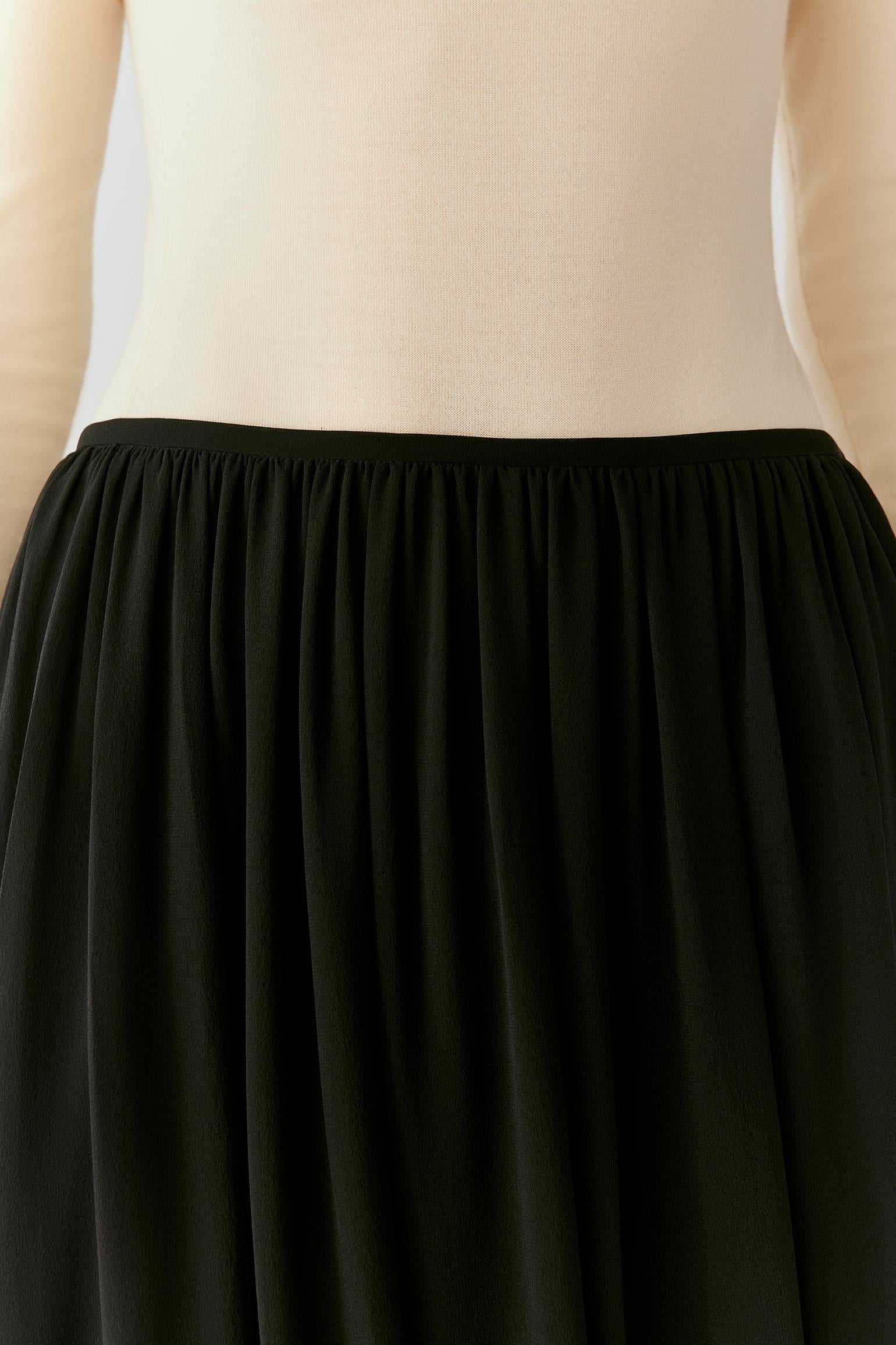Close-up of the softly gathered elasticated waistband and black silk georgette texture.