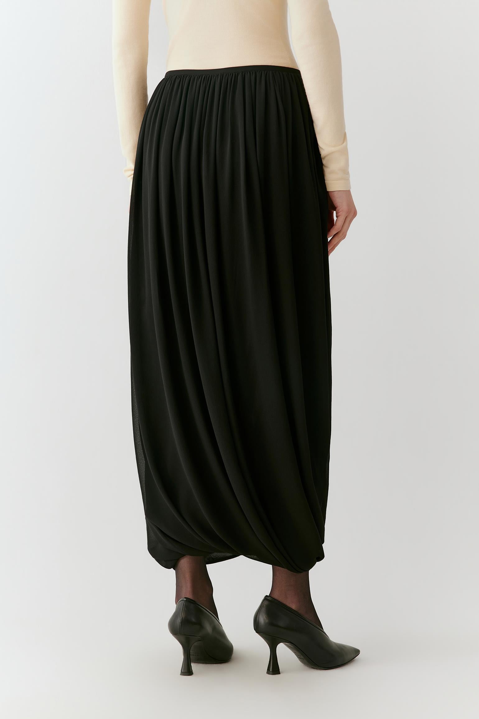 Side view showing the long silhouette, gathered volume and fluid drape of the silk georgette.
