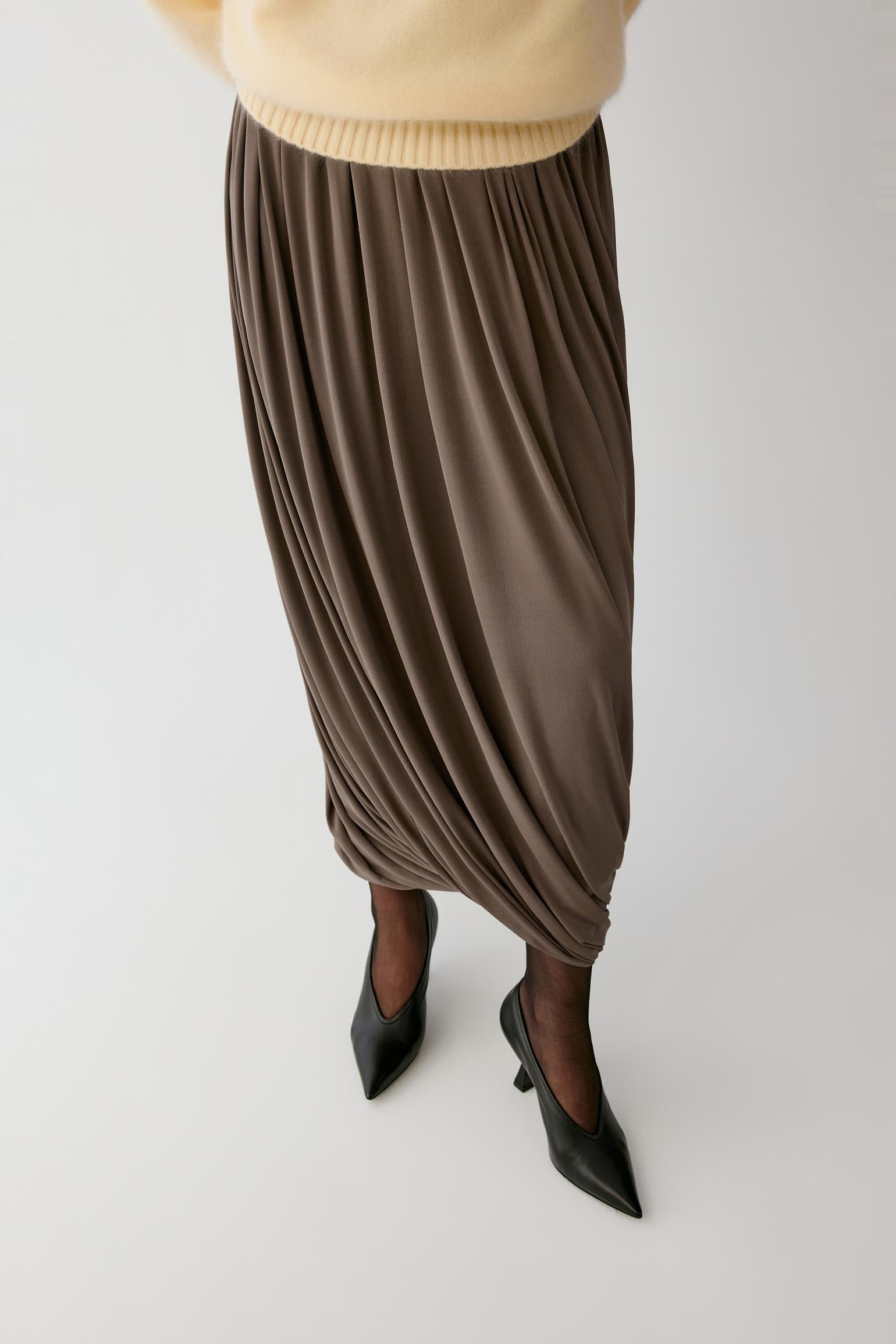 Full-length view highlighting the softly gathered hem and natural movement of the fluid silk jersey.