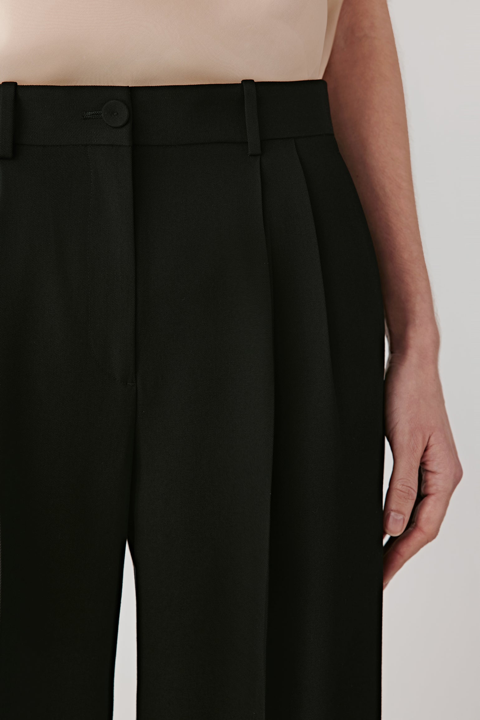 Detail close-up of waistband with belt loops, precise seams, and concealed fastening.
