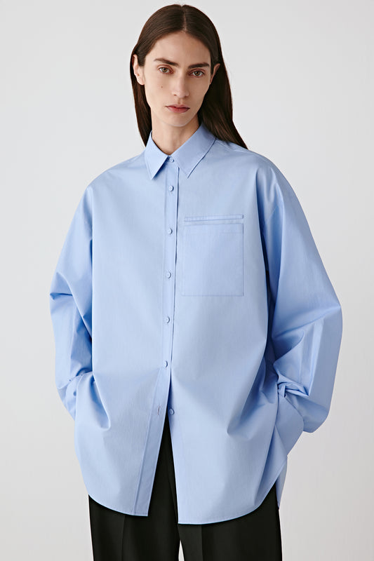 Three-quarter front view highlighting the shirt’s straight cut and smooth satin texture.