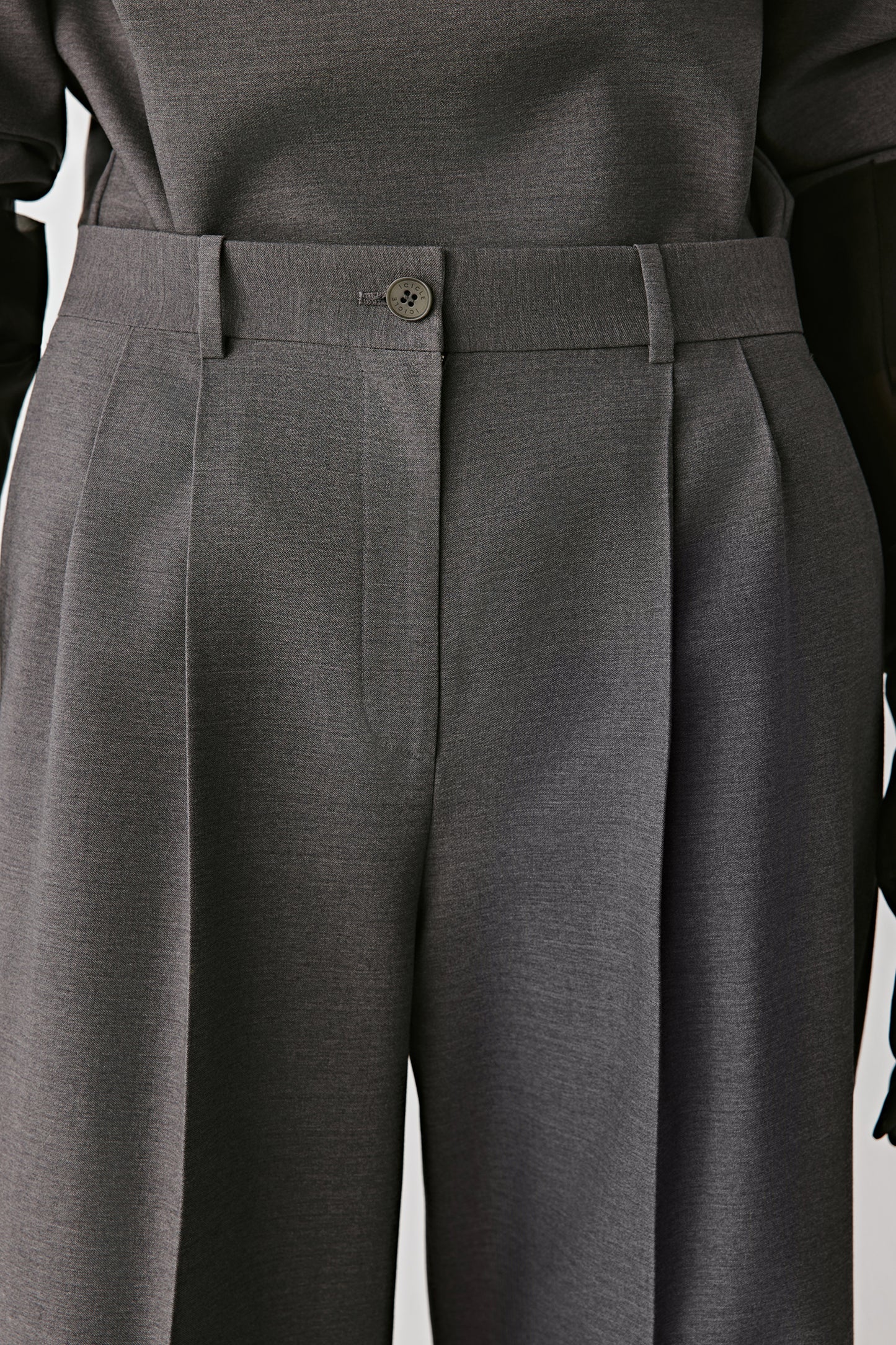 Detail of back pockets with buttons and neat stitching.