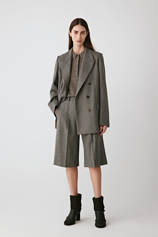 Three-quarter front view highlighting structured shoulders and refined tweed-effect weave.