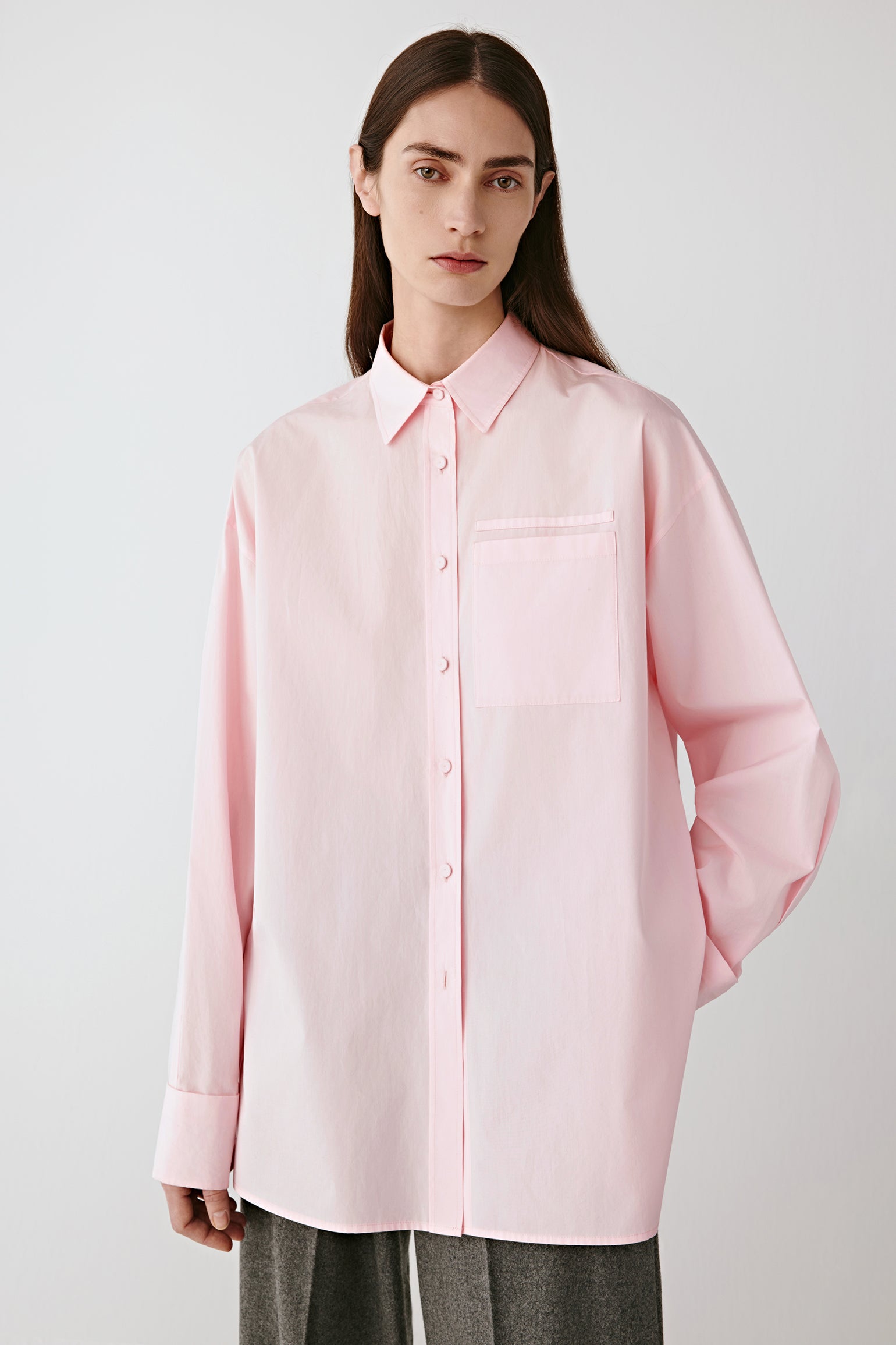 Three-quarter front view highlighting the straight cut and natural drape of the poplin fabric.