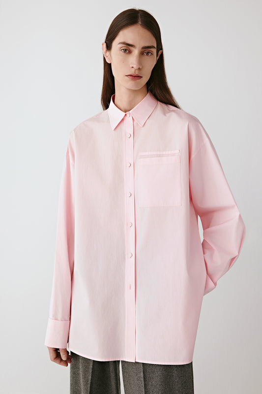 Three-quarter front view highlighting the straight cut and natural drape of the poplin fabric.