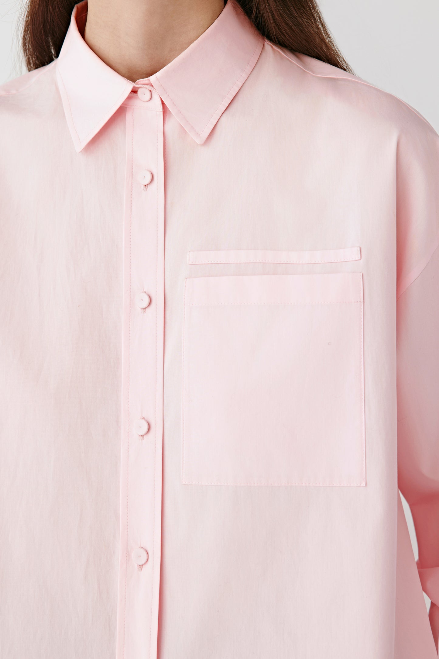 Close-up of the chest pocket and tone-on-tone button placket, showing the fine weave of the cotton.