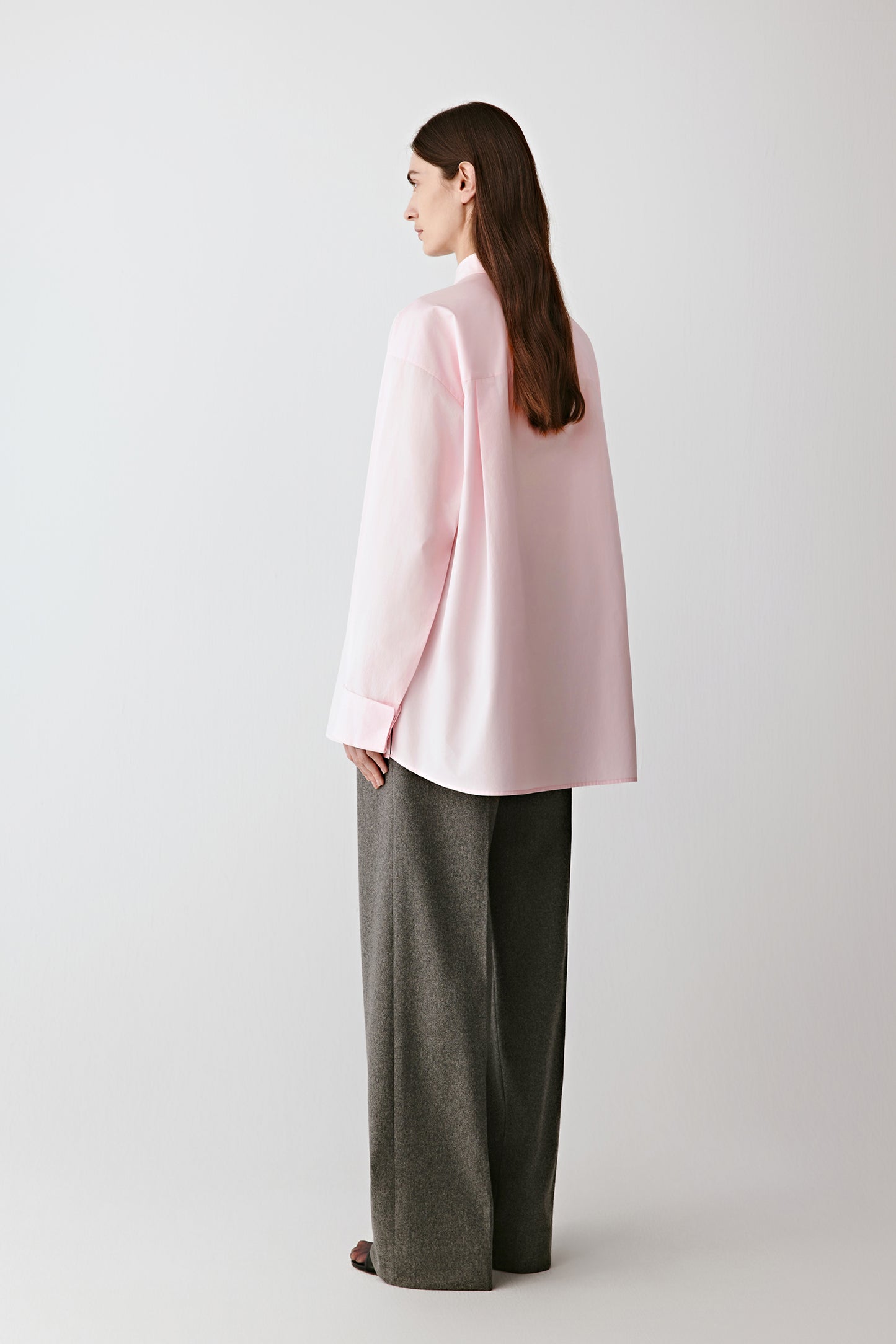 Side view capturing the shirt’s relaxed silhouette and curved hem.