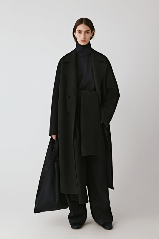 Front view of the deep blue-black double-faced wool coat, featuring wide notched lapels and a double-breasted closure.