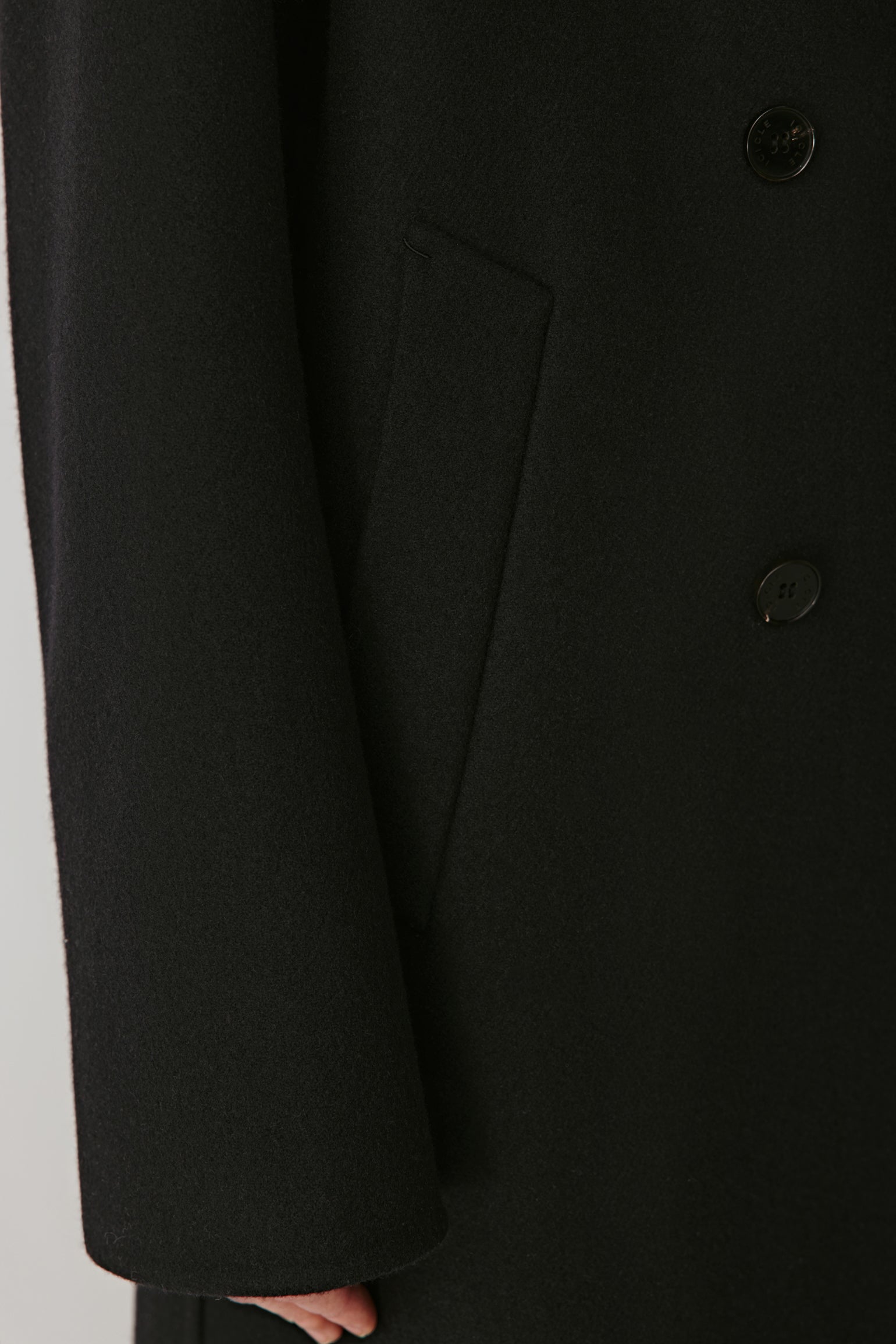 Detail shot of the front flap pocket and buttons, emphasizing fine finishing and material quality.