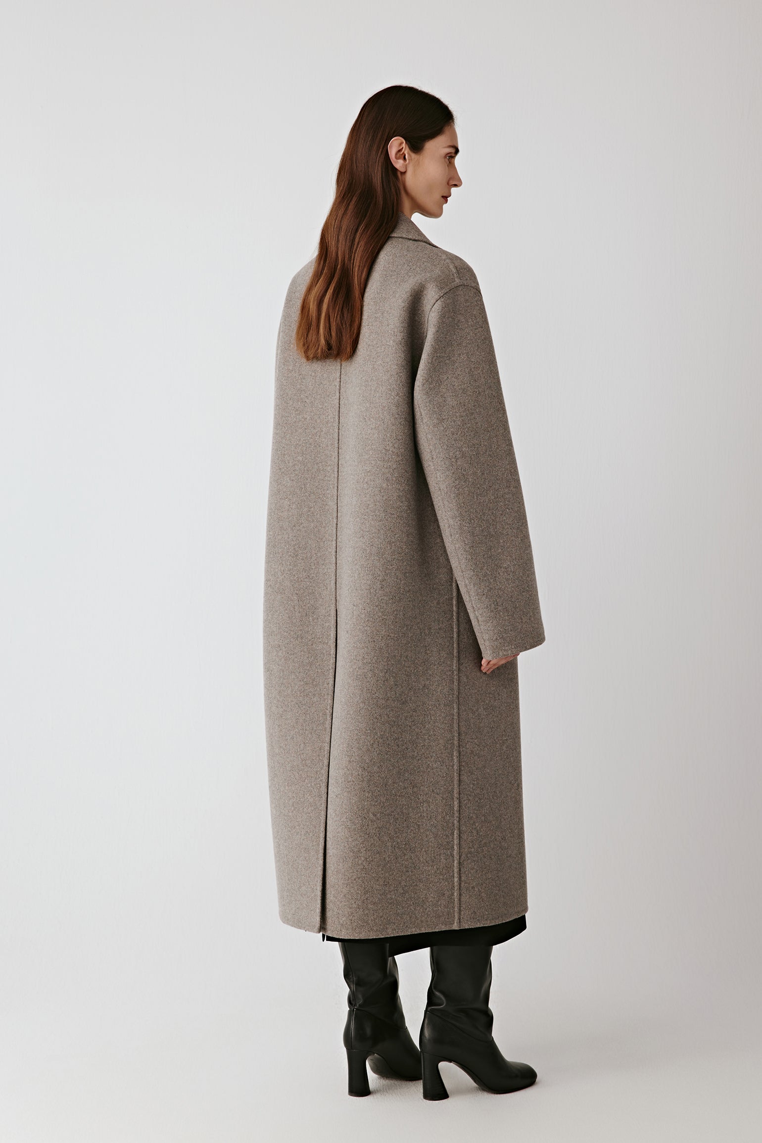 Back view of the long coat, displaying the vent and fluid movement.