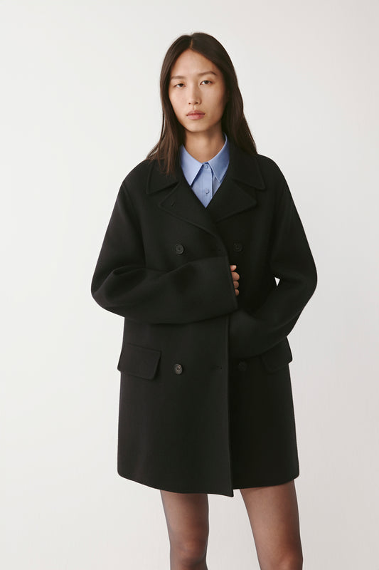 Three-quarter side view of the wool peacoat, showing the structured fit and smooth drape.