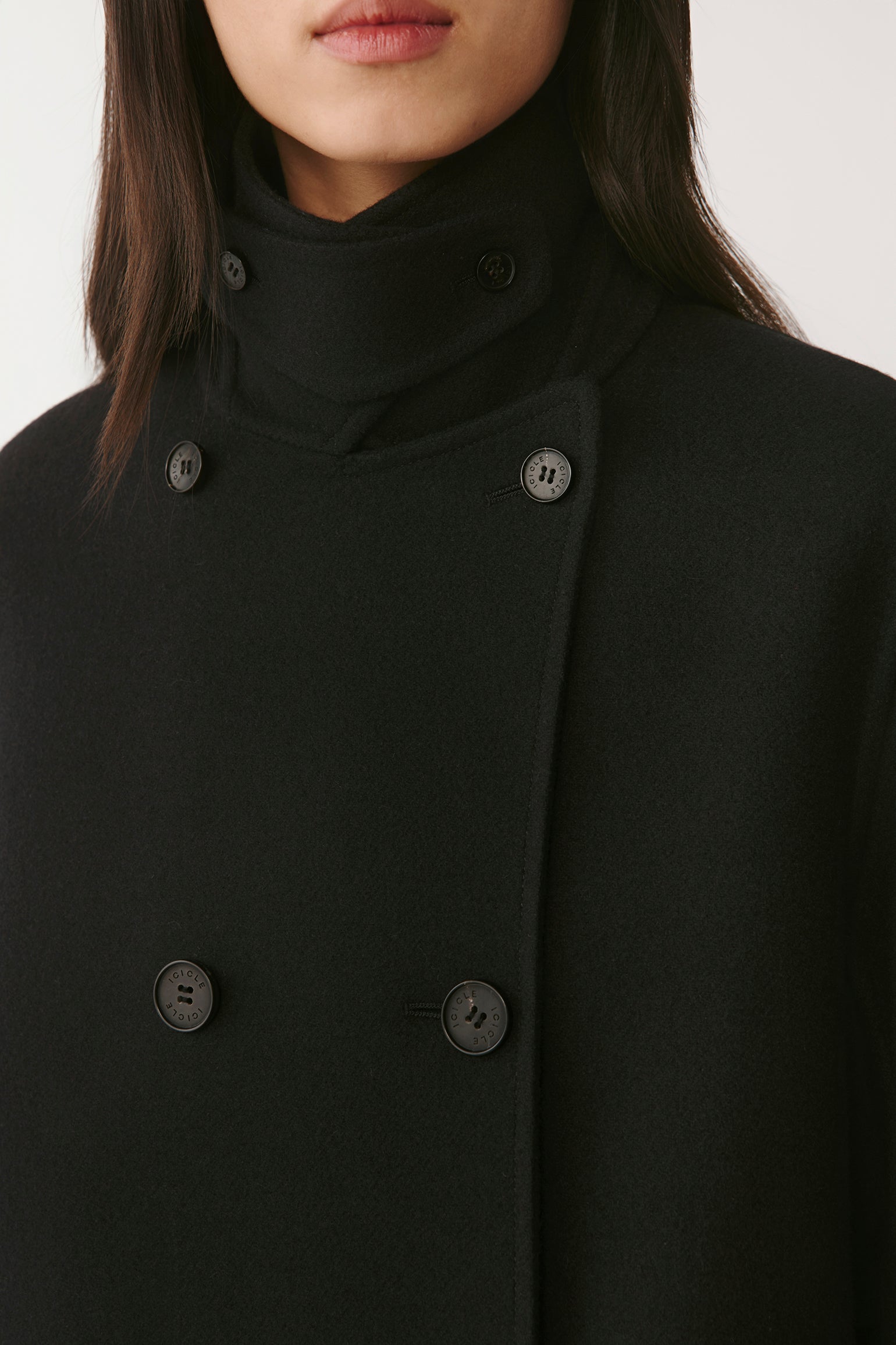 Close-up of the lapels and buttons, showing the double-breasted front and soft wool texture.