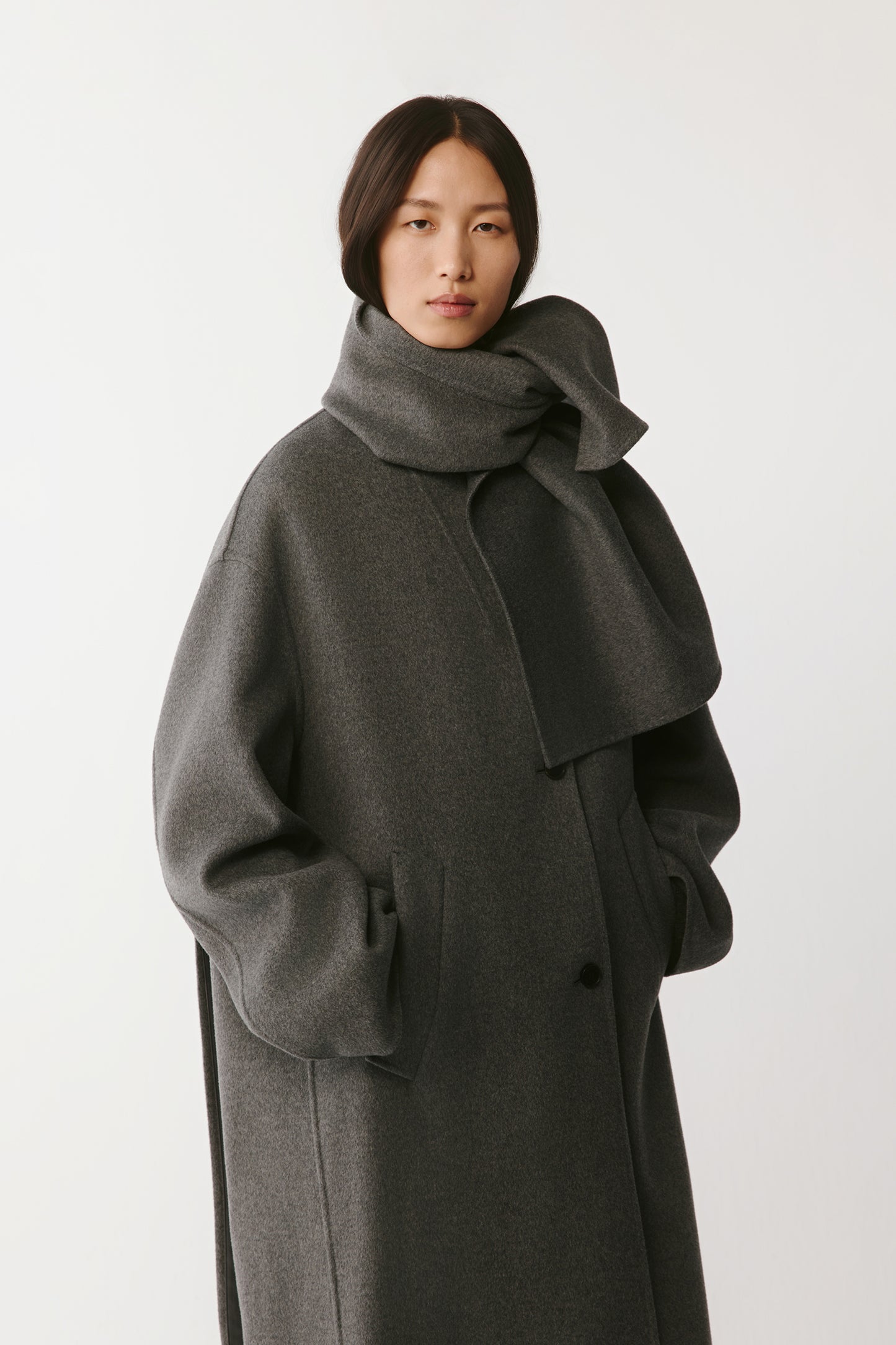 Three-quarter front view highlighting the coat's cut and relaxed sleeves.