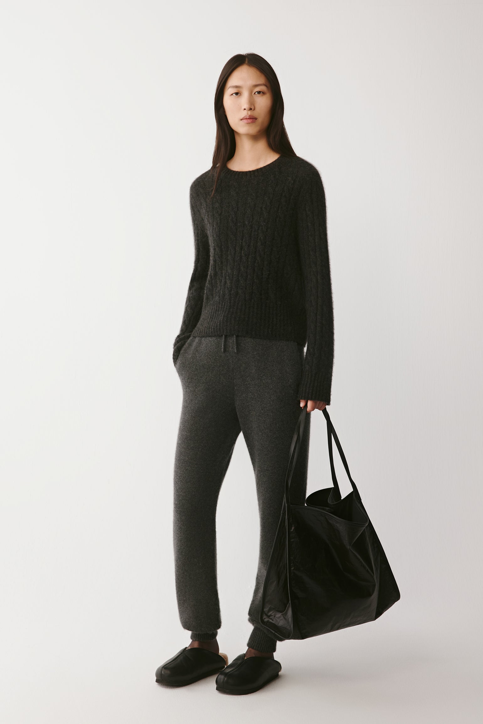 Front view of the dark grey cable-knit pullover in cashmere, alpaca and silk, with a relaxed fit and ribbed edges.