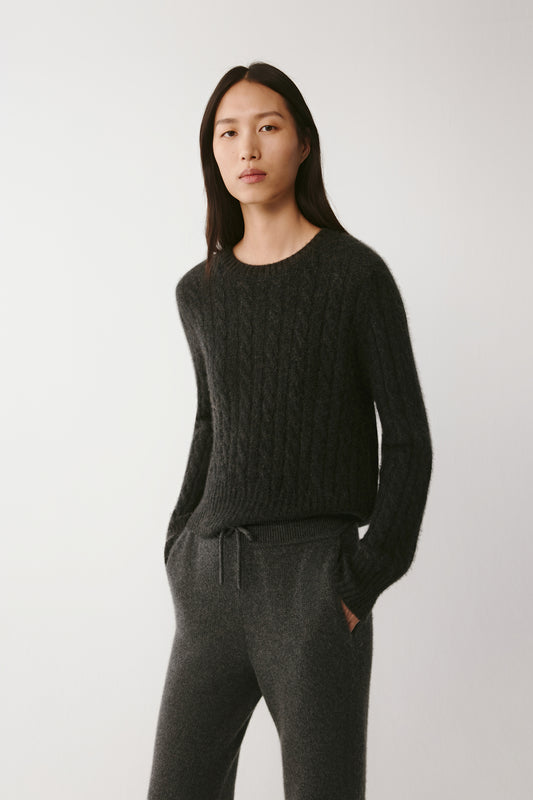 Three-quarter view of the pullover, showing the soft drape and refined cable pattern.