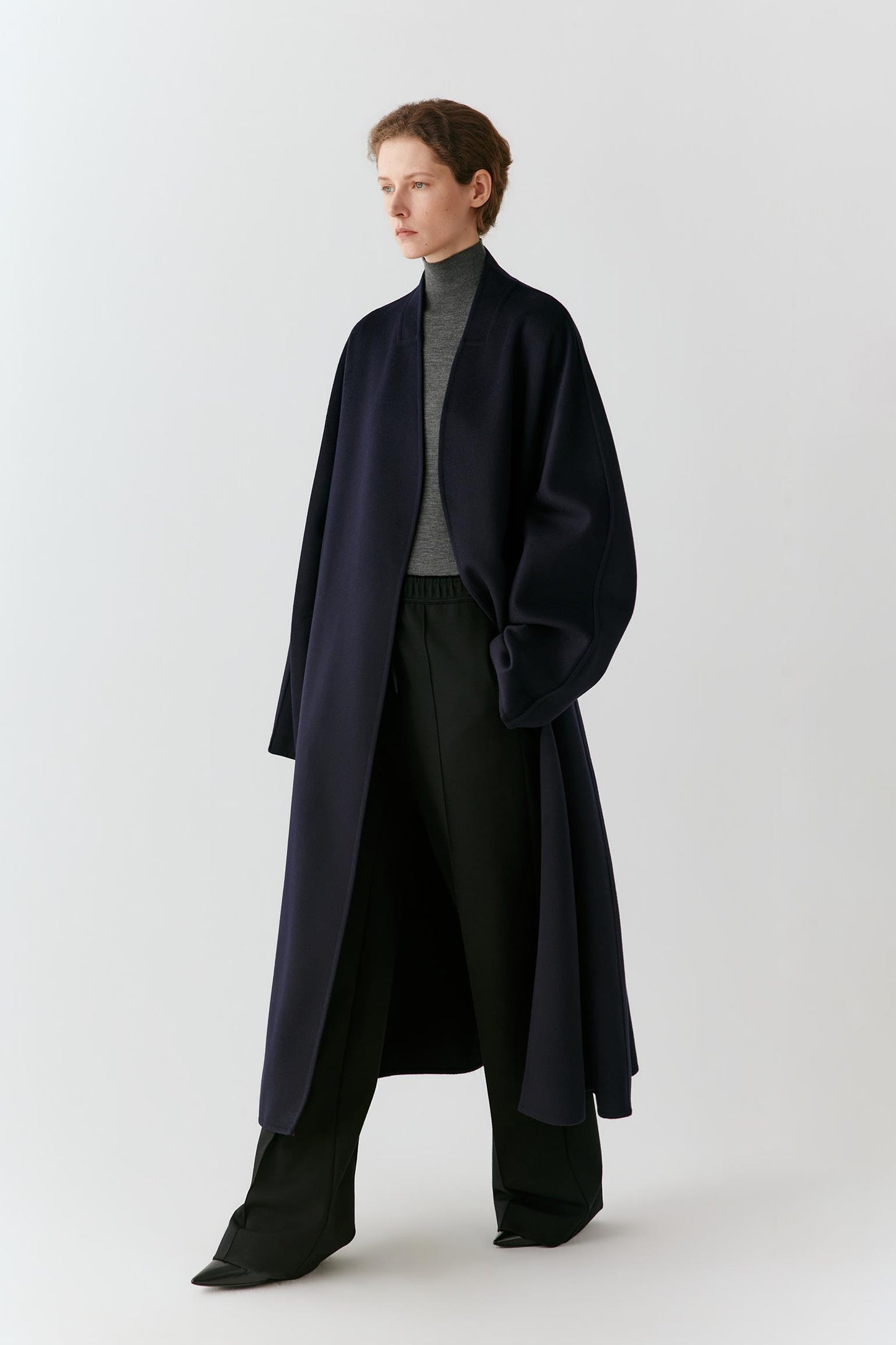 Full-length front view highlighting the open-front construction, long cut and clean lines of the coat.