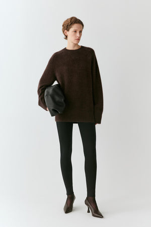 Front view of a woman wearing grey melange wool leggings, highlighting the close-fitting silhouette and full-length legs.