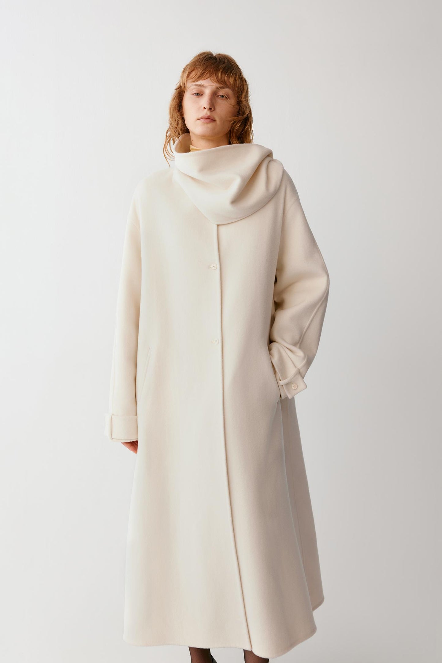 Full-length front view emphasizing the long cut, concealed fastening and fluid drape of the double-face fabric.