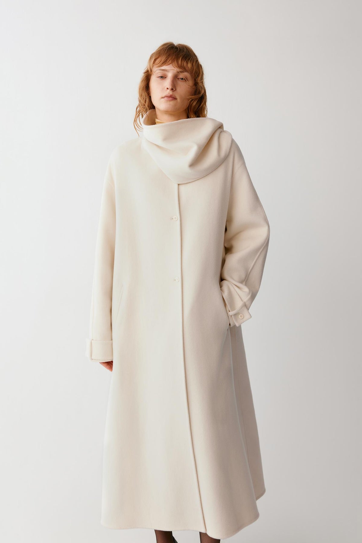 Full-length front view emphasizing the long cut, concealed fastening and fluid drape of the double-face fabric.