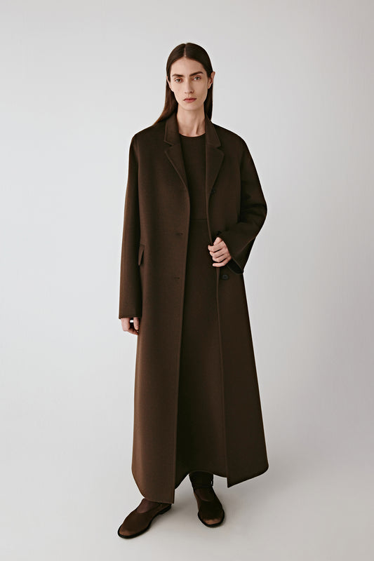 Full-length front view of the long brown double-faced wool and silk coat with clean tailored lines and a straight silhouette.