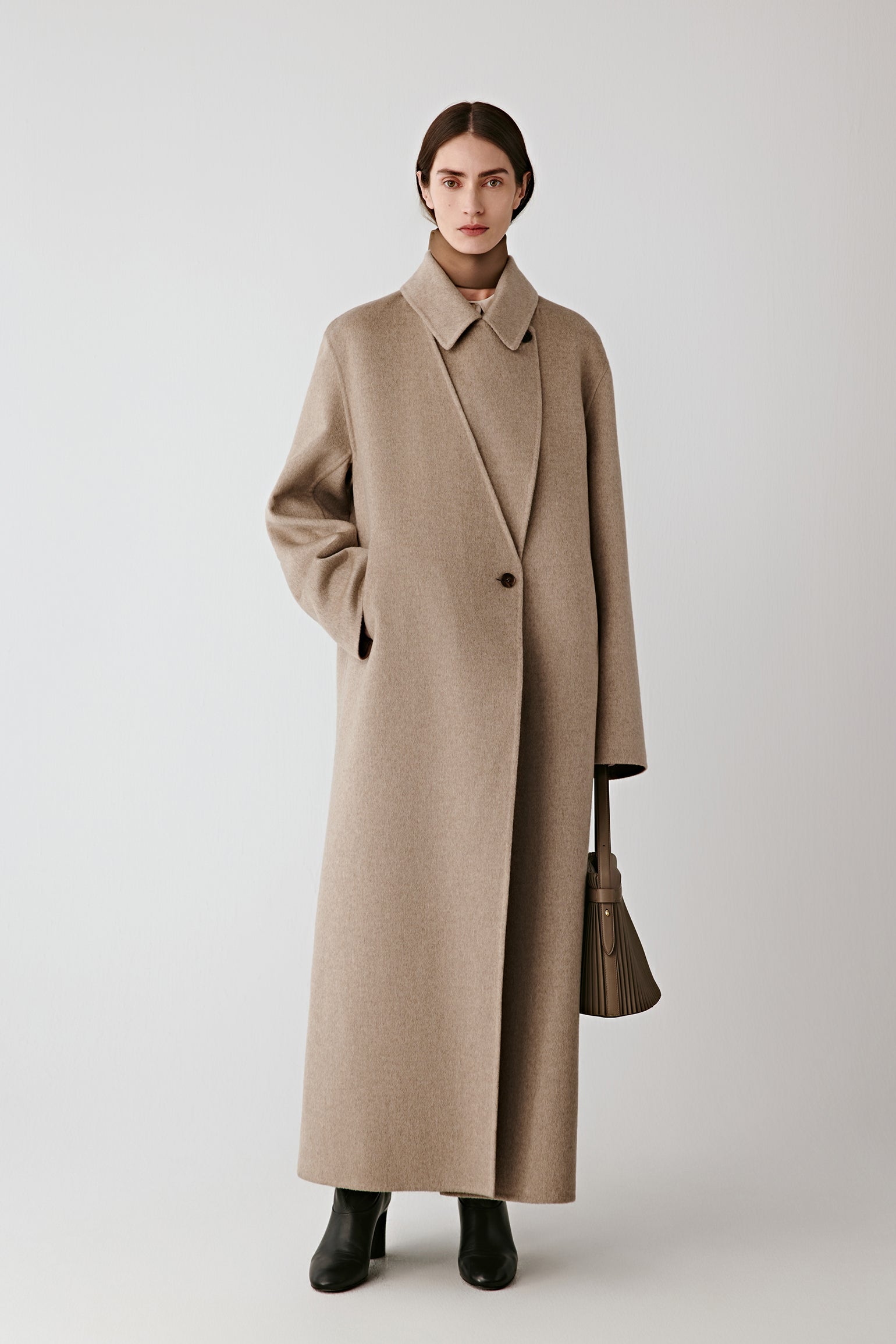 Full-length front view of the model wearing the undyed taupe double-faced cashmere coat.