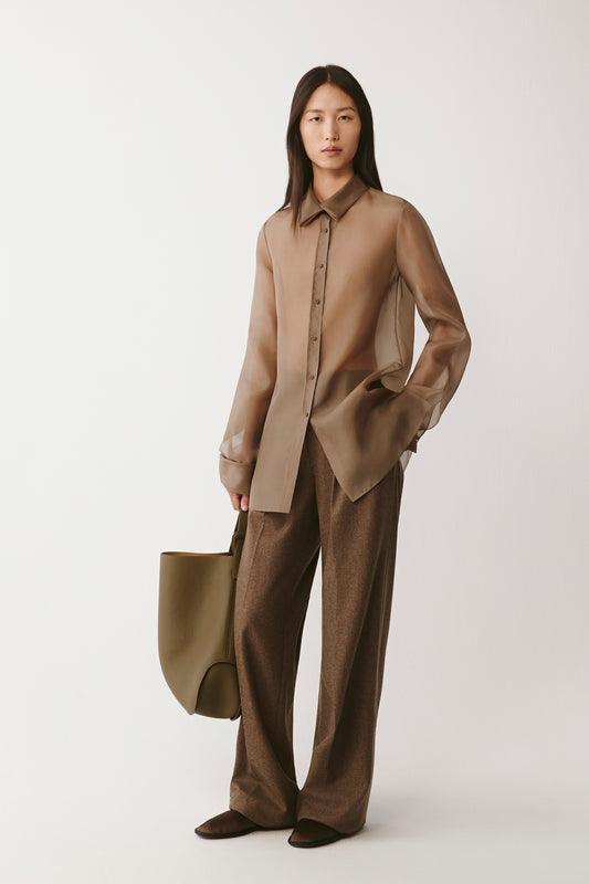 Full-length front view of the model wearing the brown silk organza shirt with wide-leg trousers.