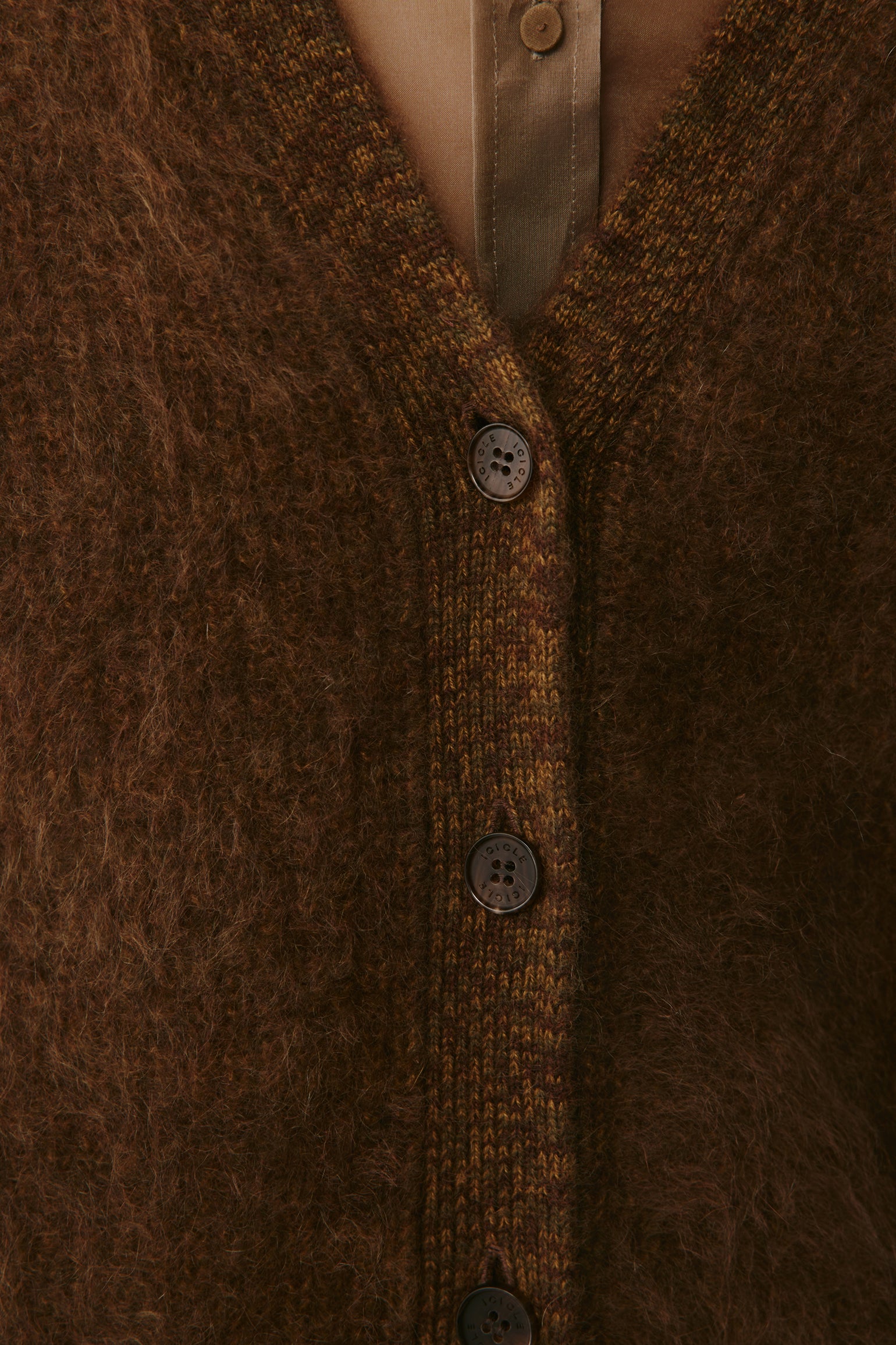 Close-up of the button placket and V-neckline showing the knit texture.