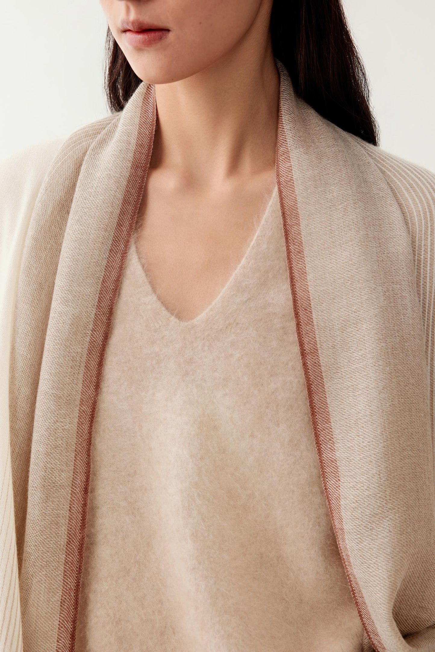 Close-up of the undyed cashmere fabric, revealing fine fibres and subtle natural colour variations.