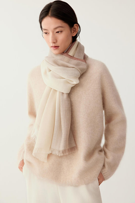 Three-quarter view of the cashmere scarf worn around the shoulders, highlighting its lightweight texture and fluid fall.