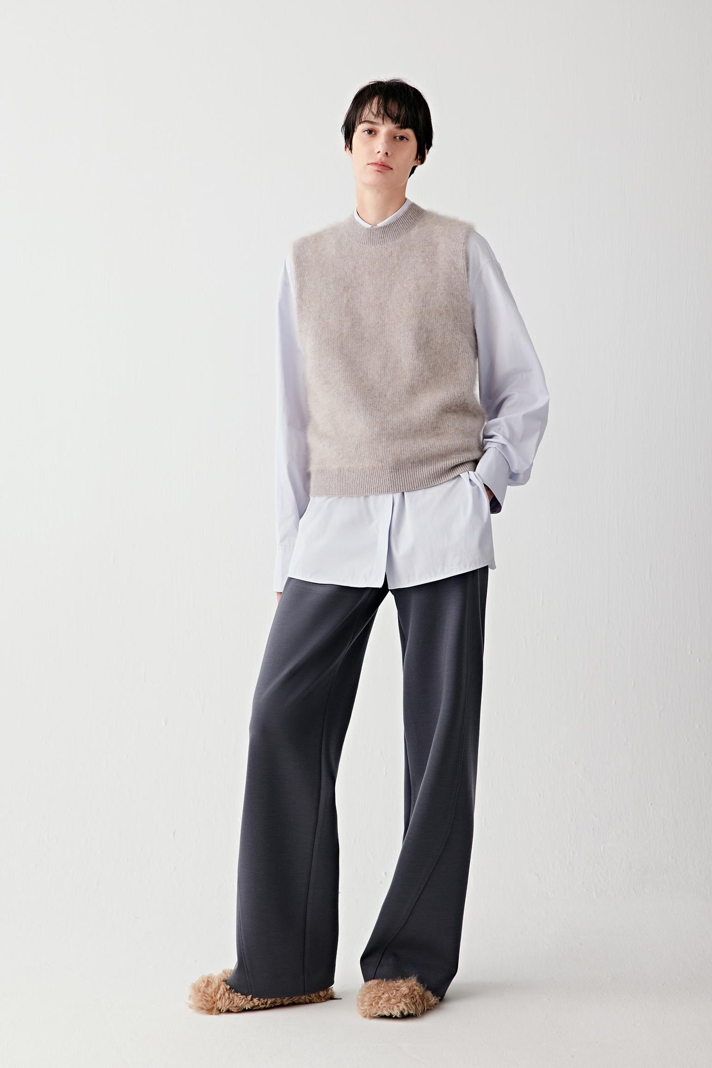 Full-length front view of a wool and cashmere pullover in a subtle lavender mélange tone, worn layered over a white shirt.