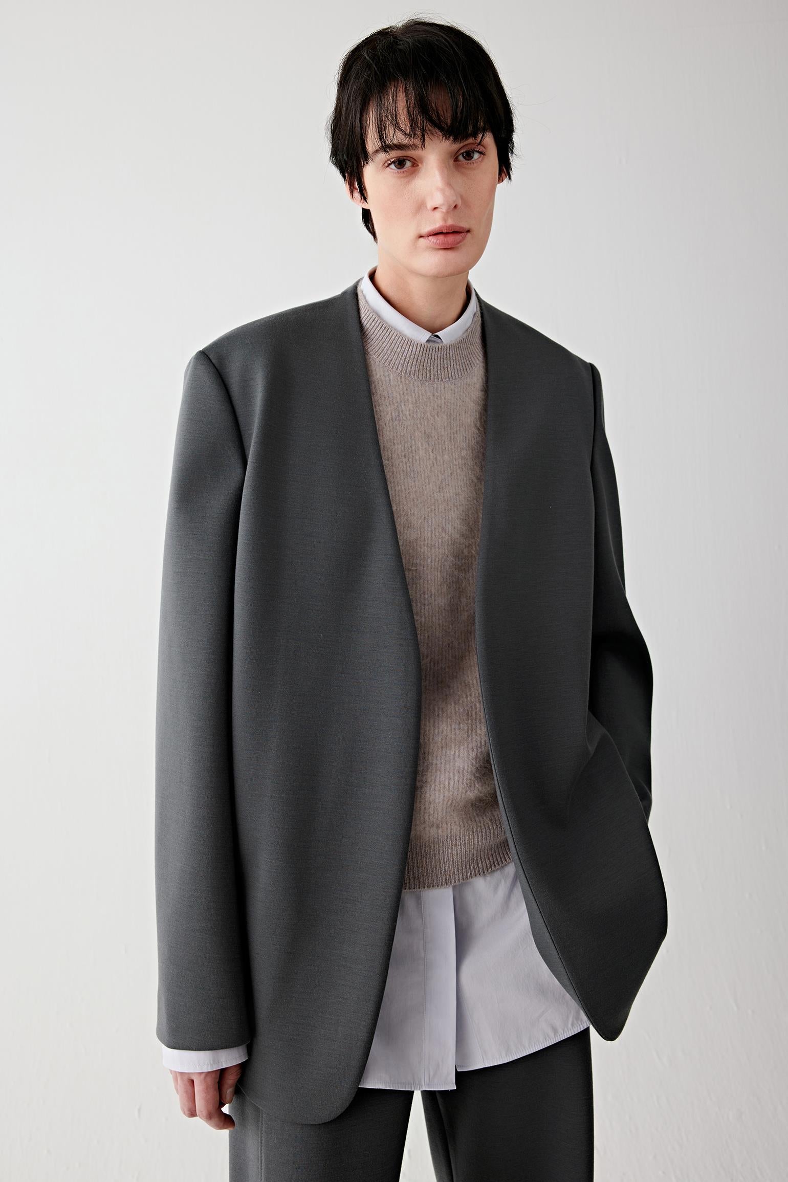 Three-quarter front view showing the tailored cut and fluid structure of the wool jersey blazer.
