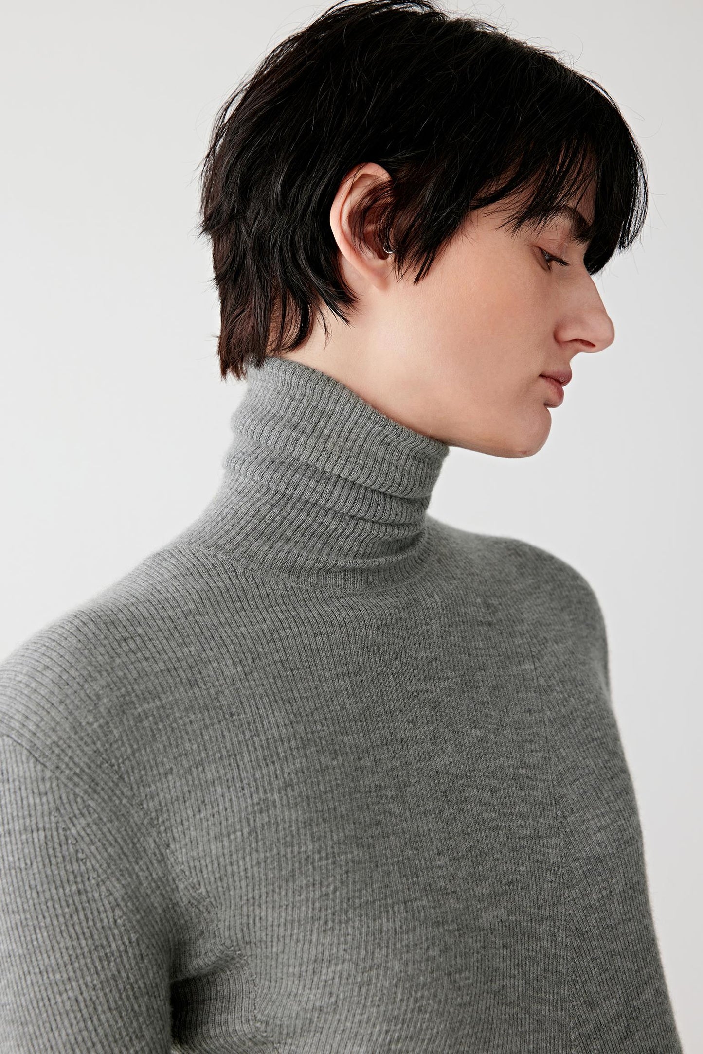 Close-up of the neckline and shoulder area, revealing the fine gauge knit and clean edges.