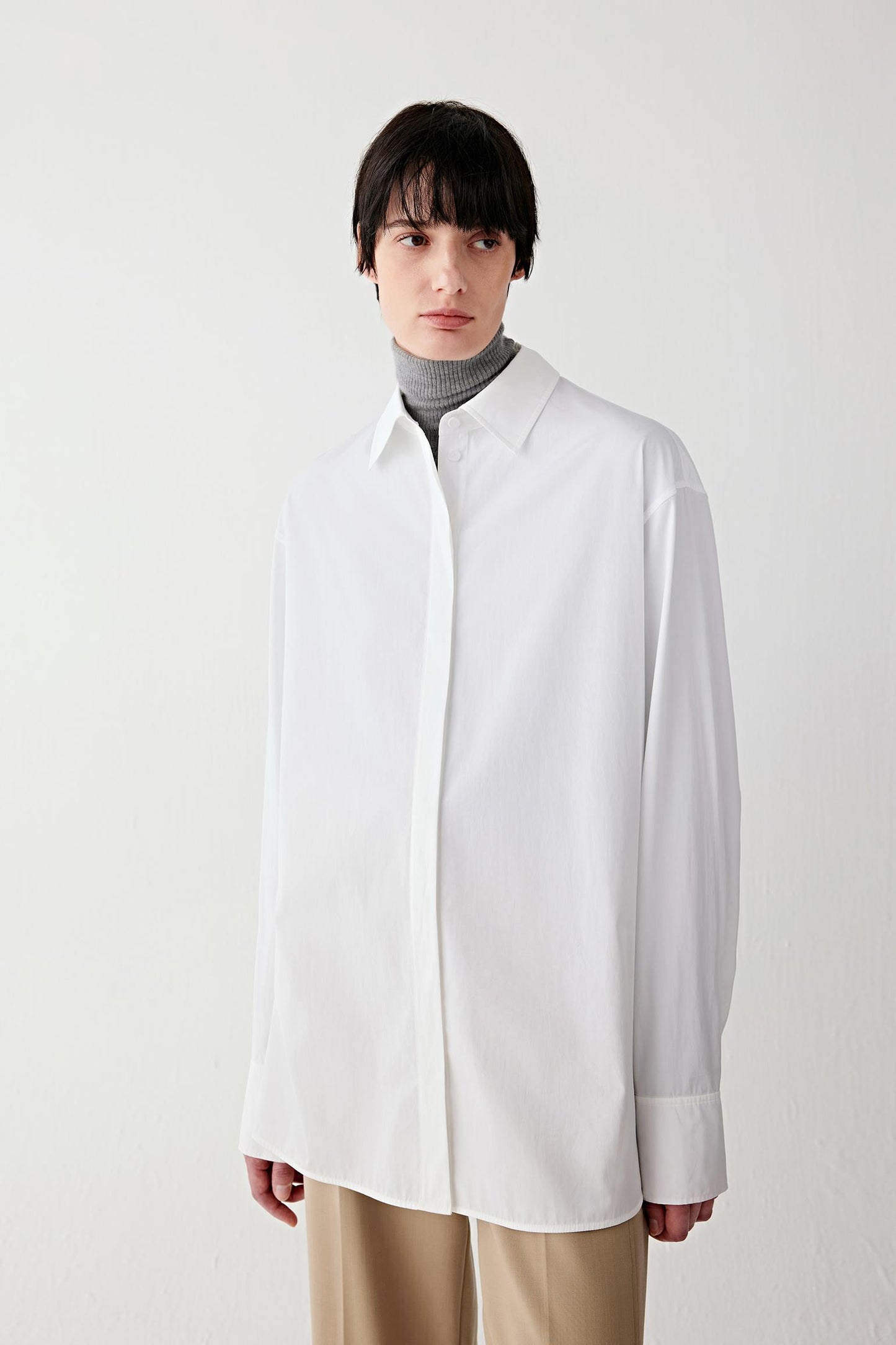 Three-quarter front view showing the crisp drape and clean lines of the cotton poplin fabric.