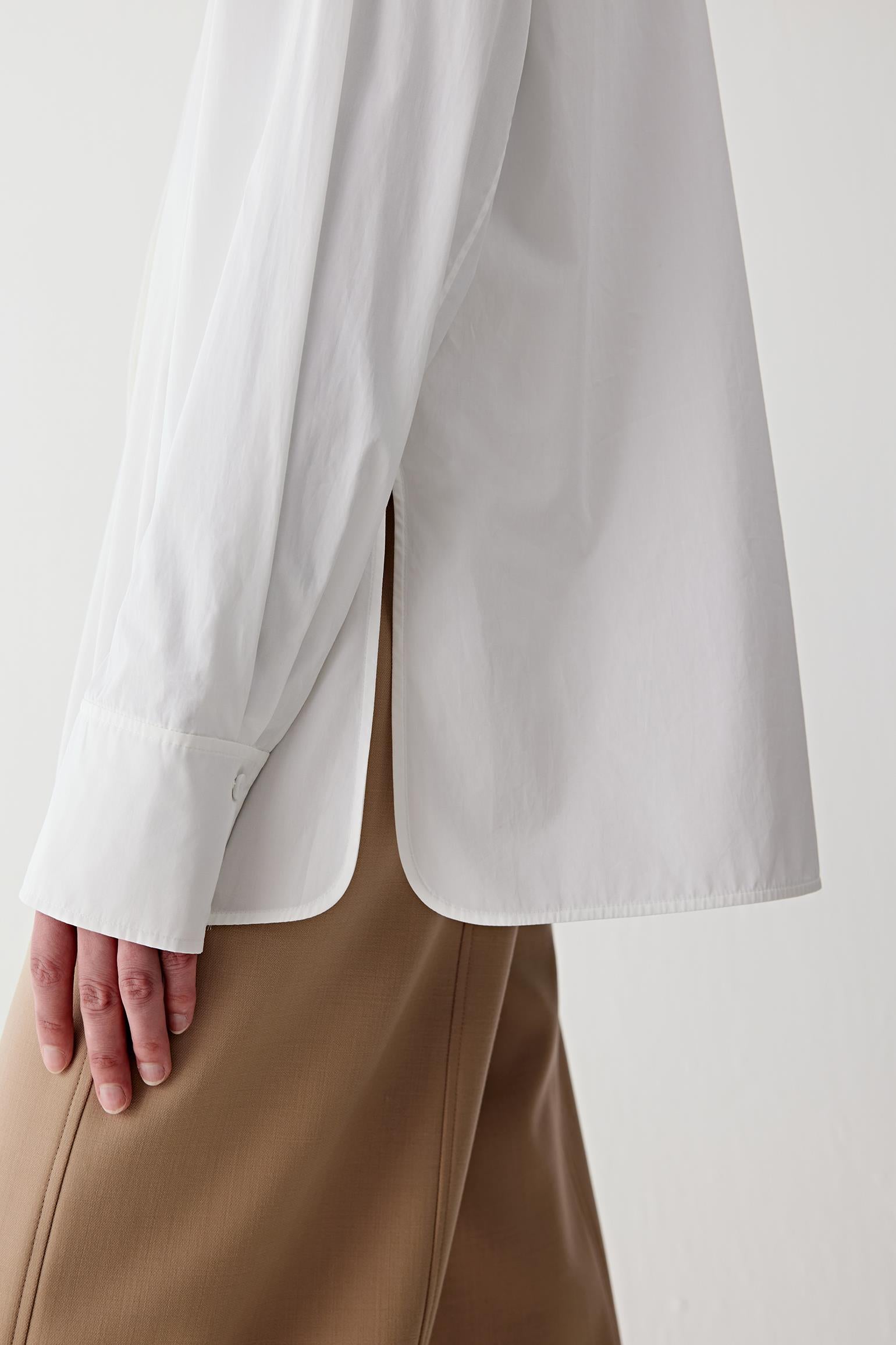 Detail close-up of the cuff and sleeve, showing precise stitching and lightweight fabric.