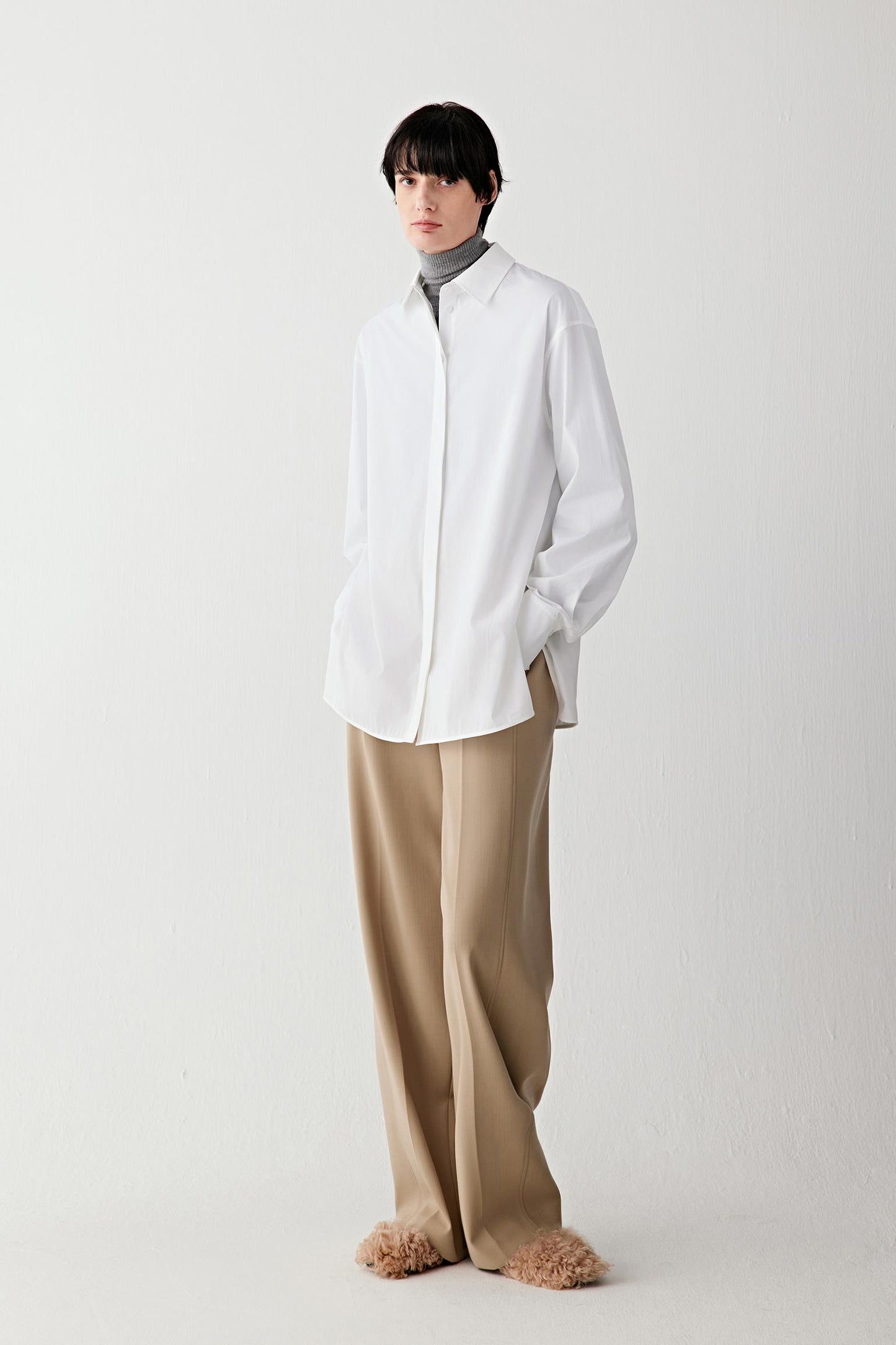 Full-length front view of a white cotton poplin shirt with a straight, softly relaxed fit.