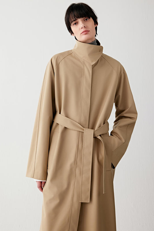 Three-quarter front view highlighting the elongated cut, press-stud collar and fluid drape of the fabric.