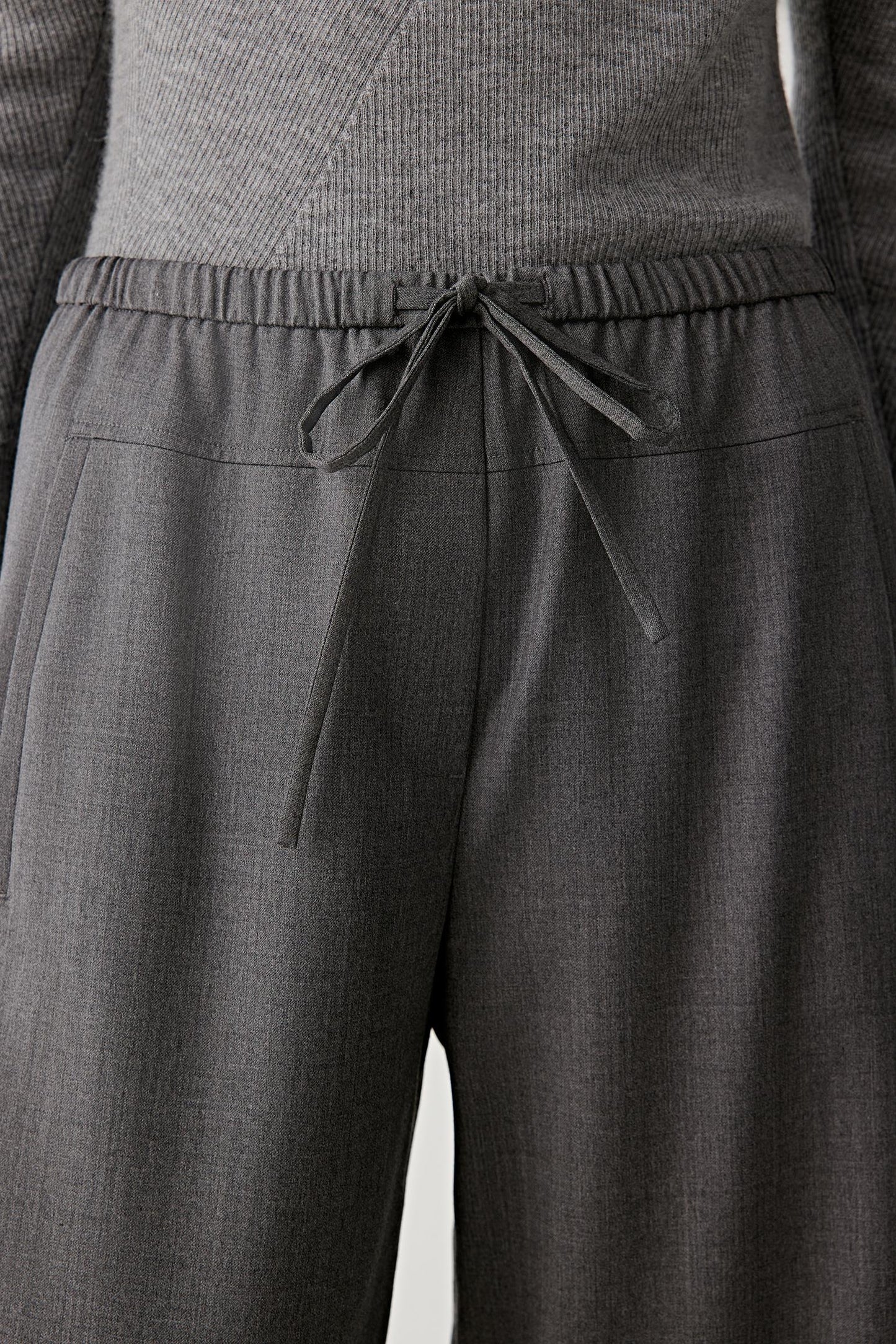 Close-up of the drawstring waist detail in light wool twill.