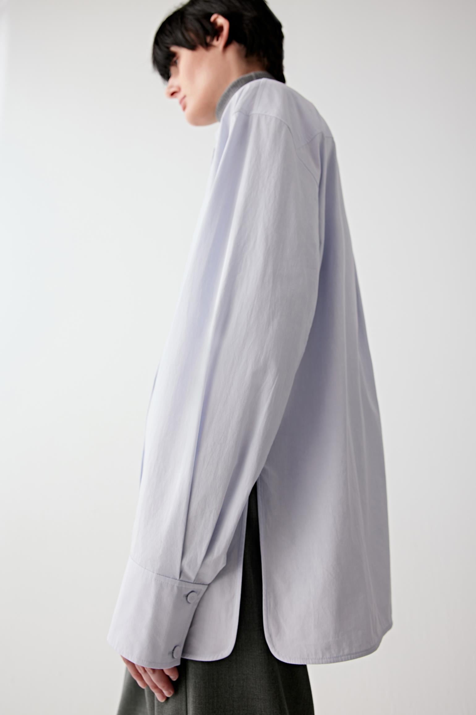 Detail of the sleeve and side hem in light blue cotton poplin.